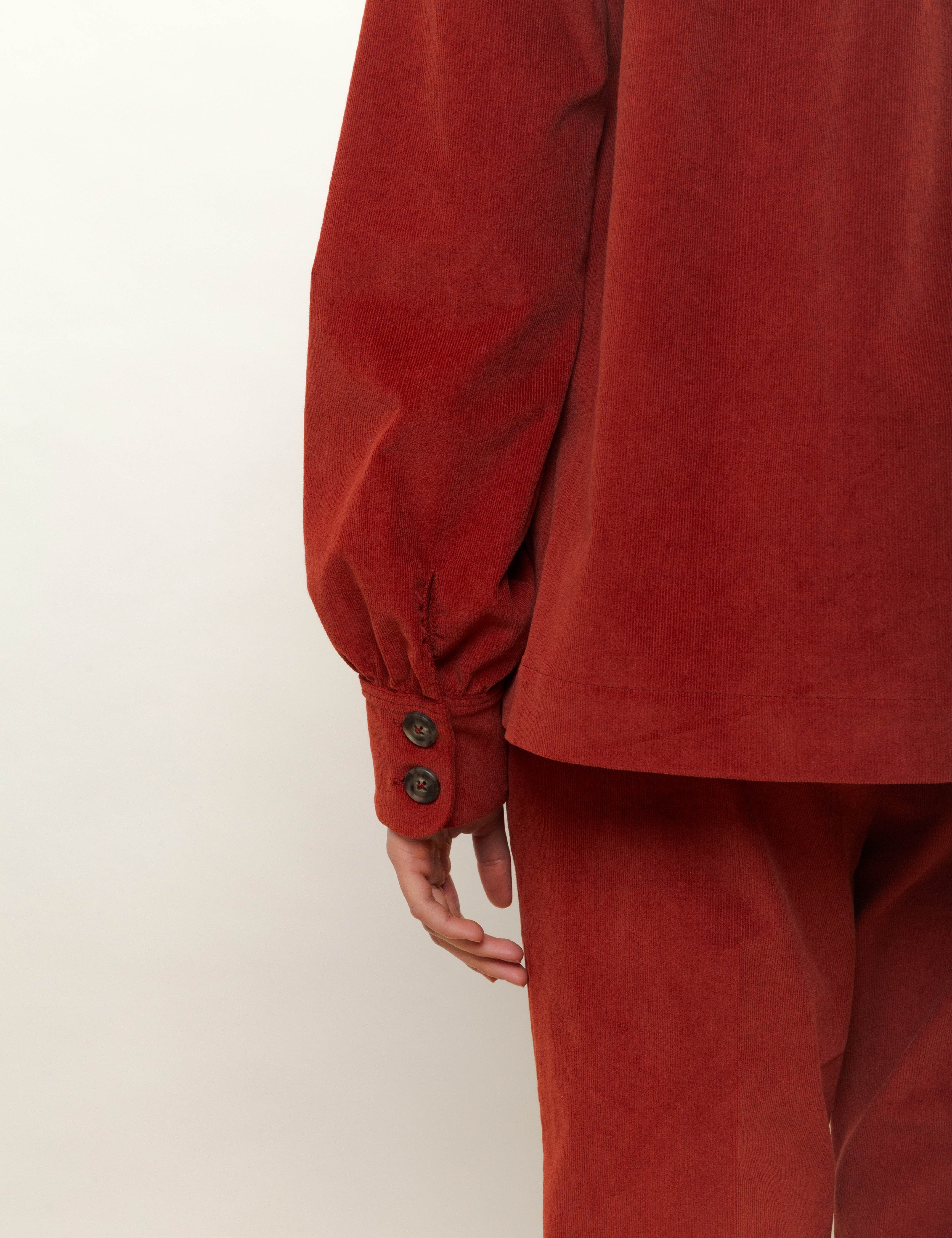 Woman in red corduroy pants and jacket with buttons