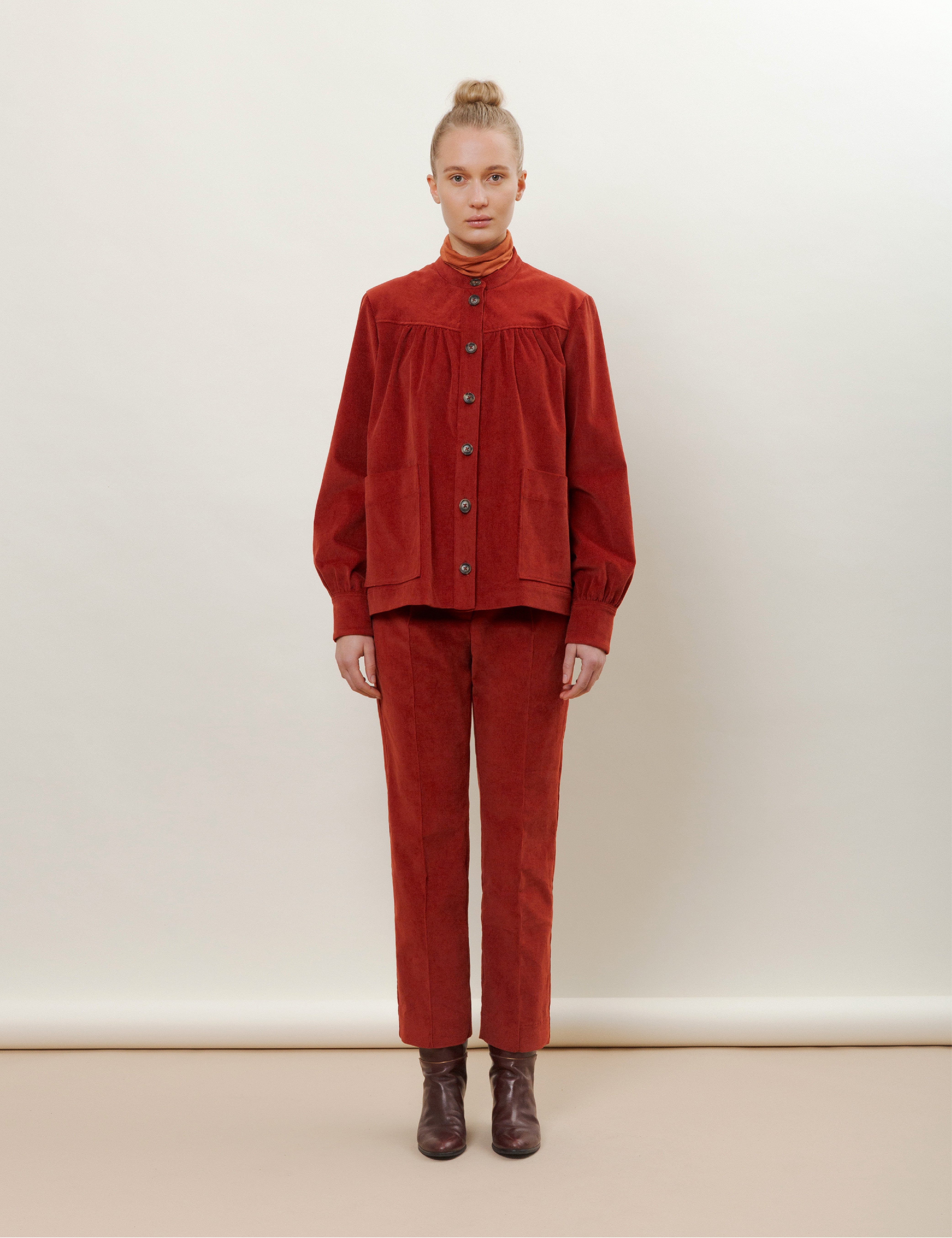 Woman in red corduroy pants and jacket with pockets and buttons