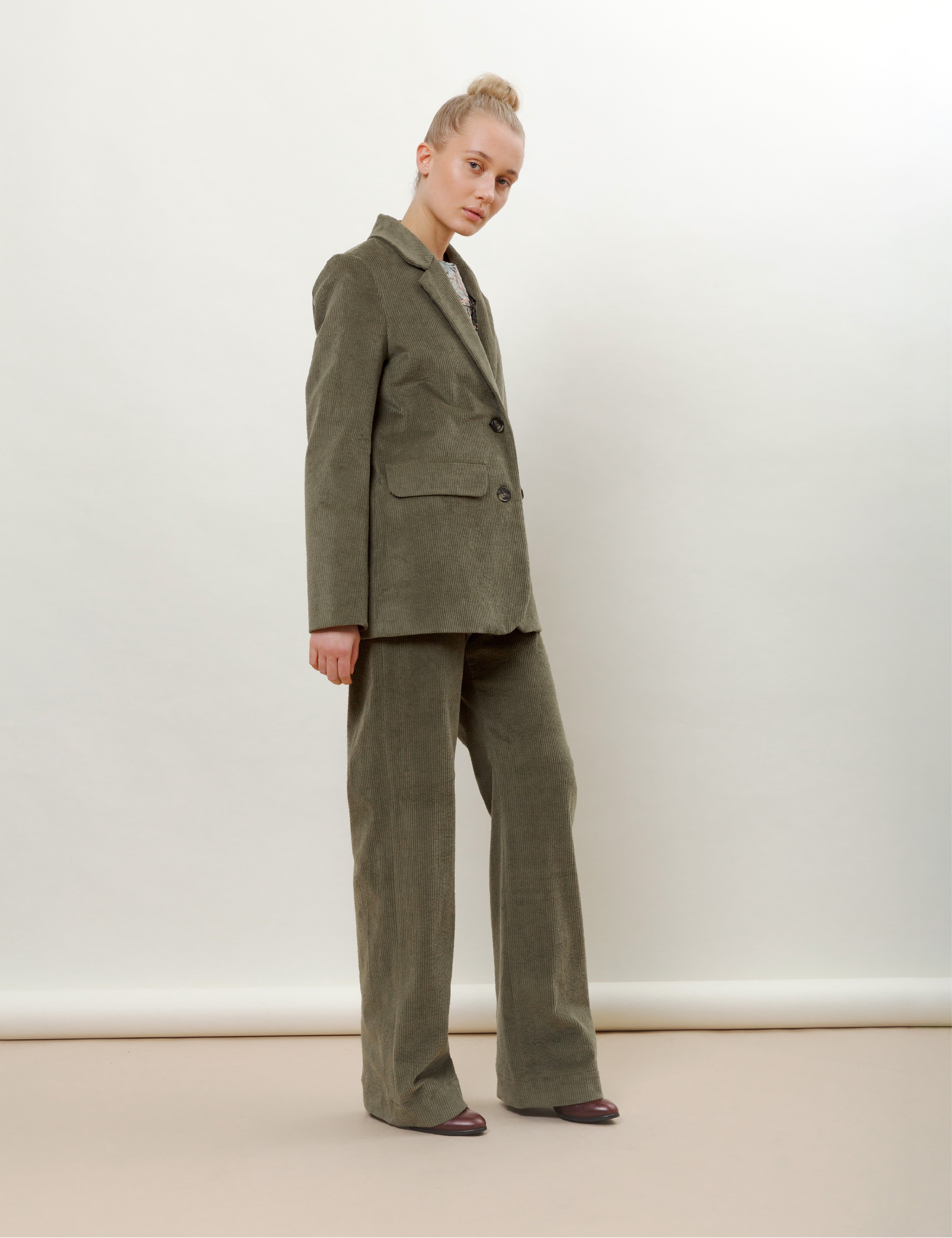 Woman in olive green corduroy jacket and pants