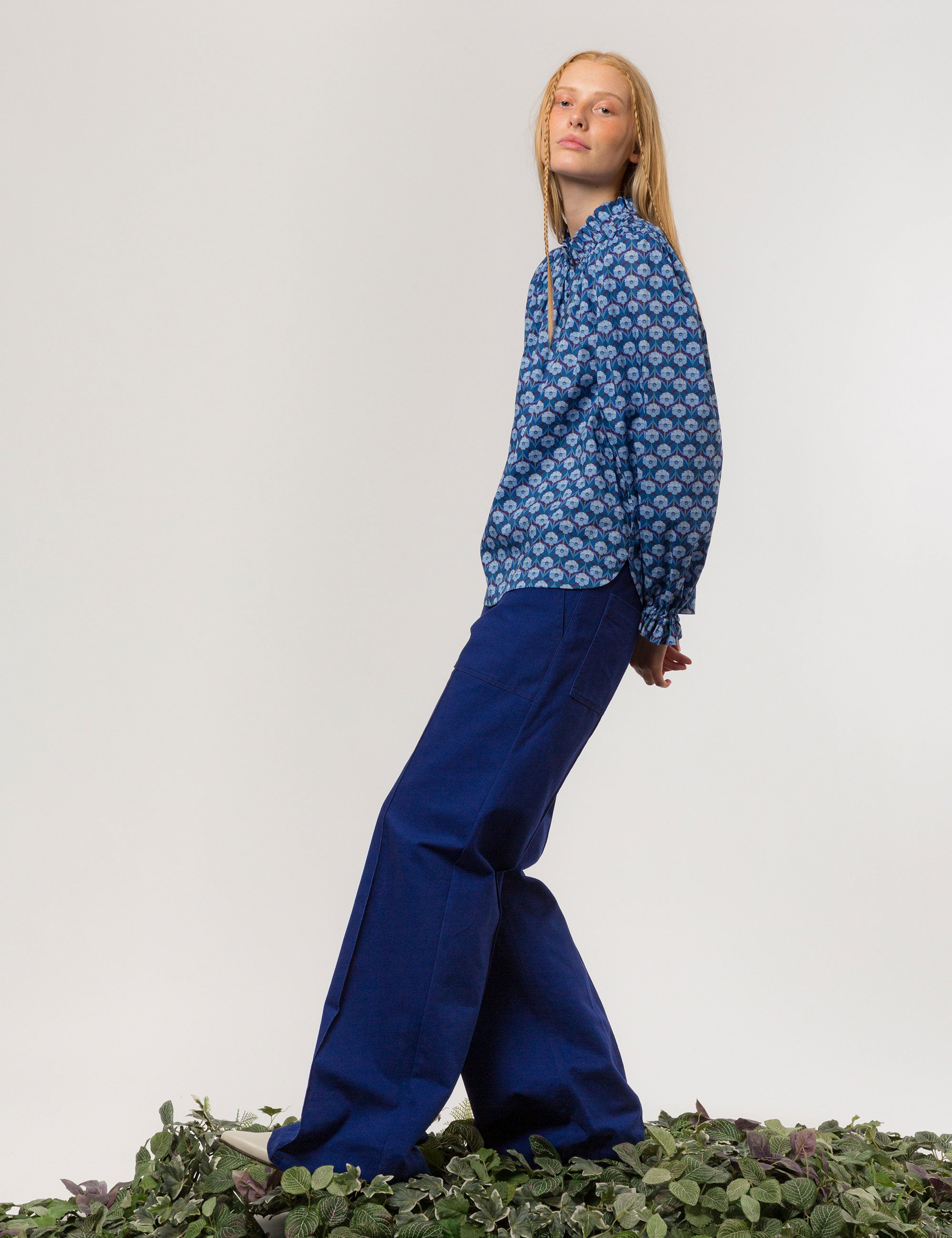 Woman in liberty cotton blue floral print shirt with frilled cuffs and collar and blue pants