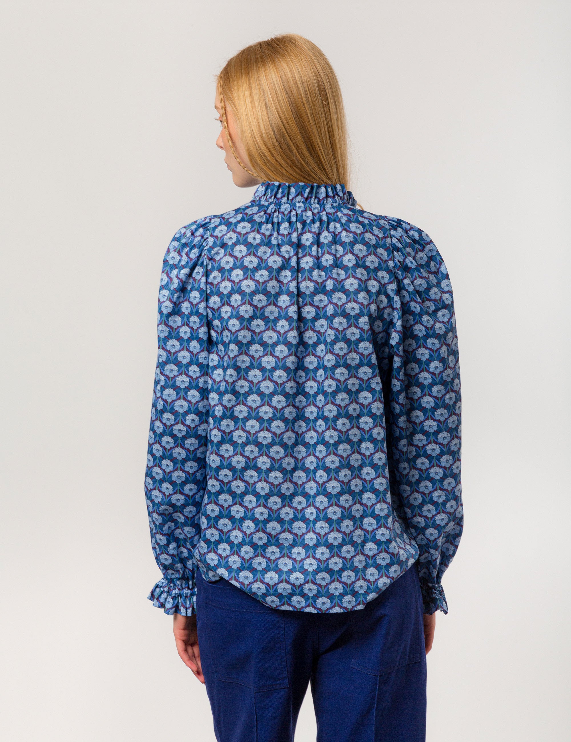 Woman in liberty cotton blue floral print shirt with frilled cuffs and collar and blue pants