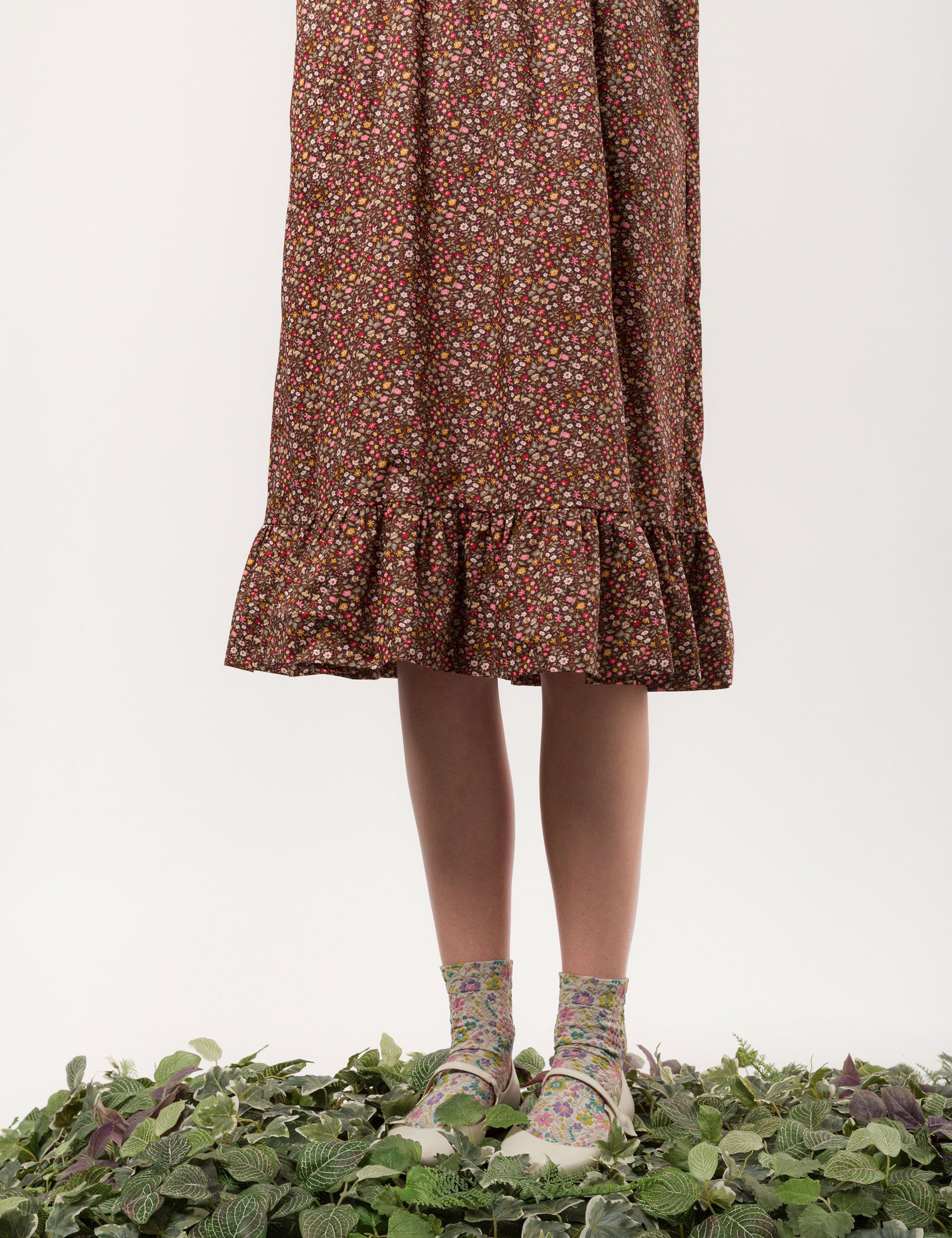 Woman in liberty cotton brown floral print midi dress with long sleeves and buttons