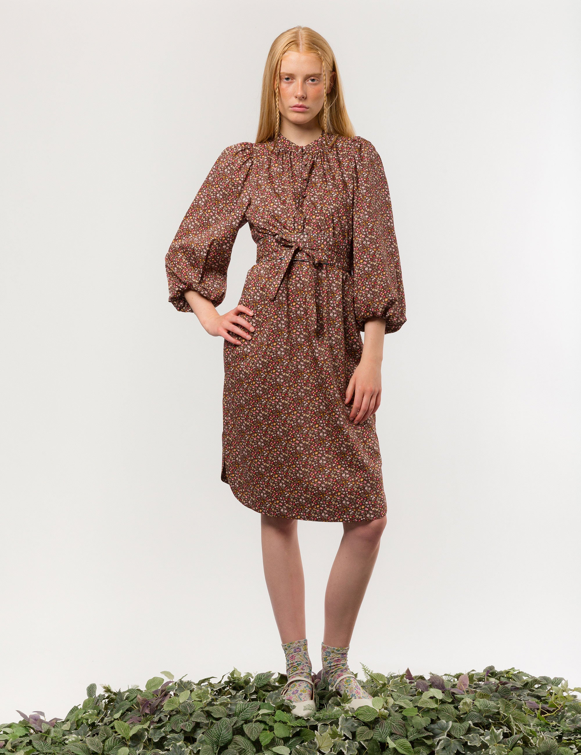 Woman in brown floral print midi dress in liberty cotton with long puff sleeves and matching belt