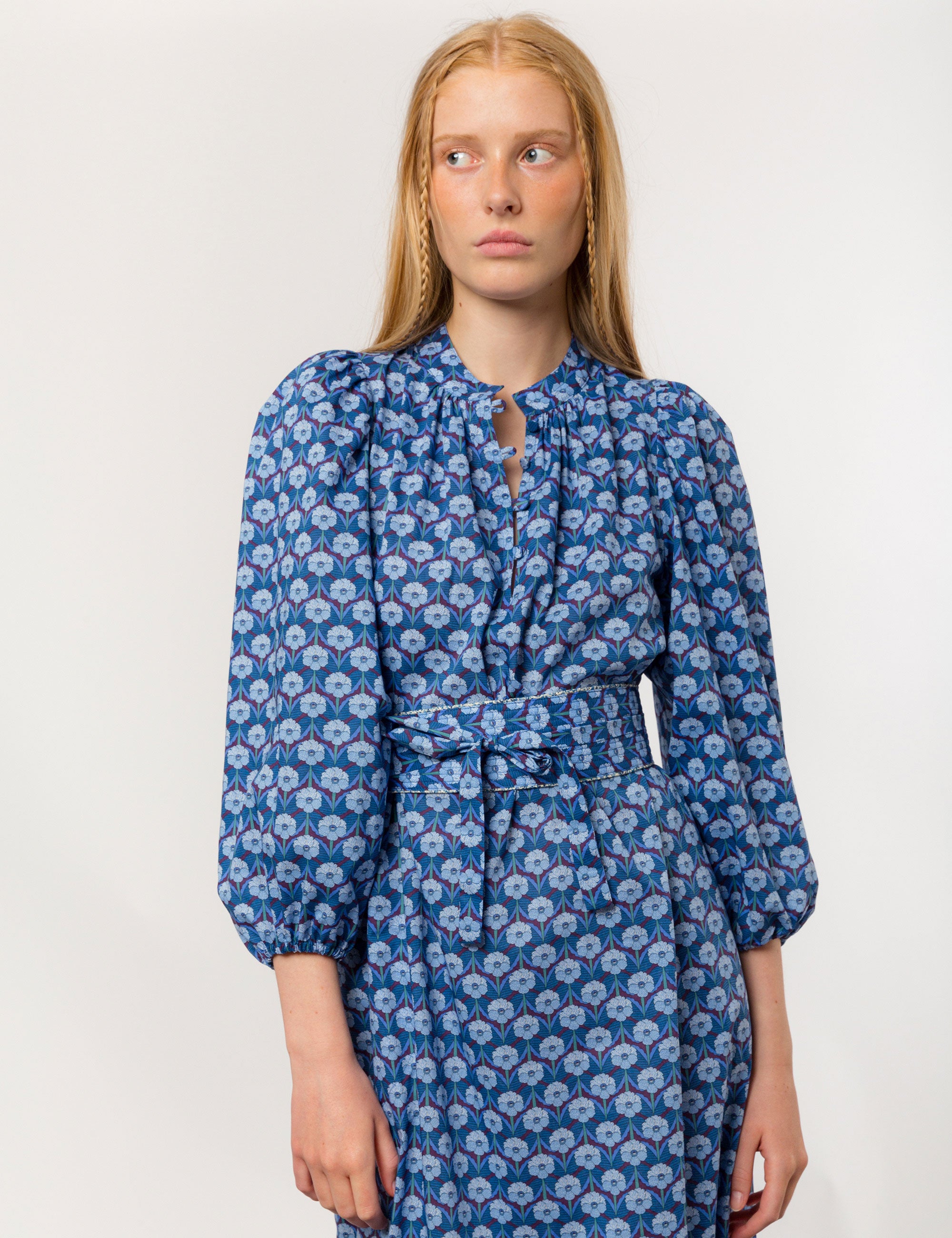 Woman in danish designed blue floral print maxi dress in premium Liberty cotton with long puffed sleeves and matching belt