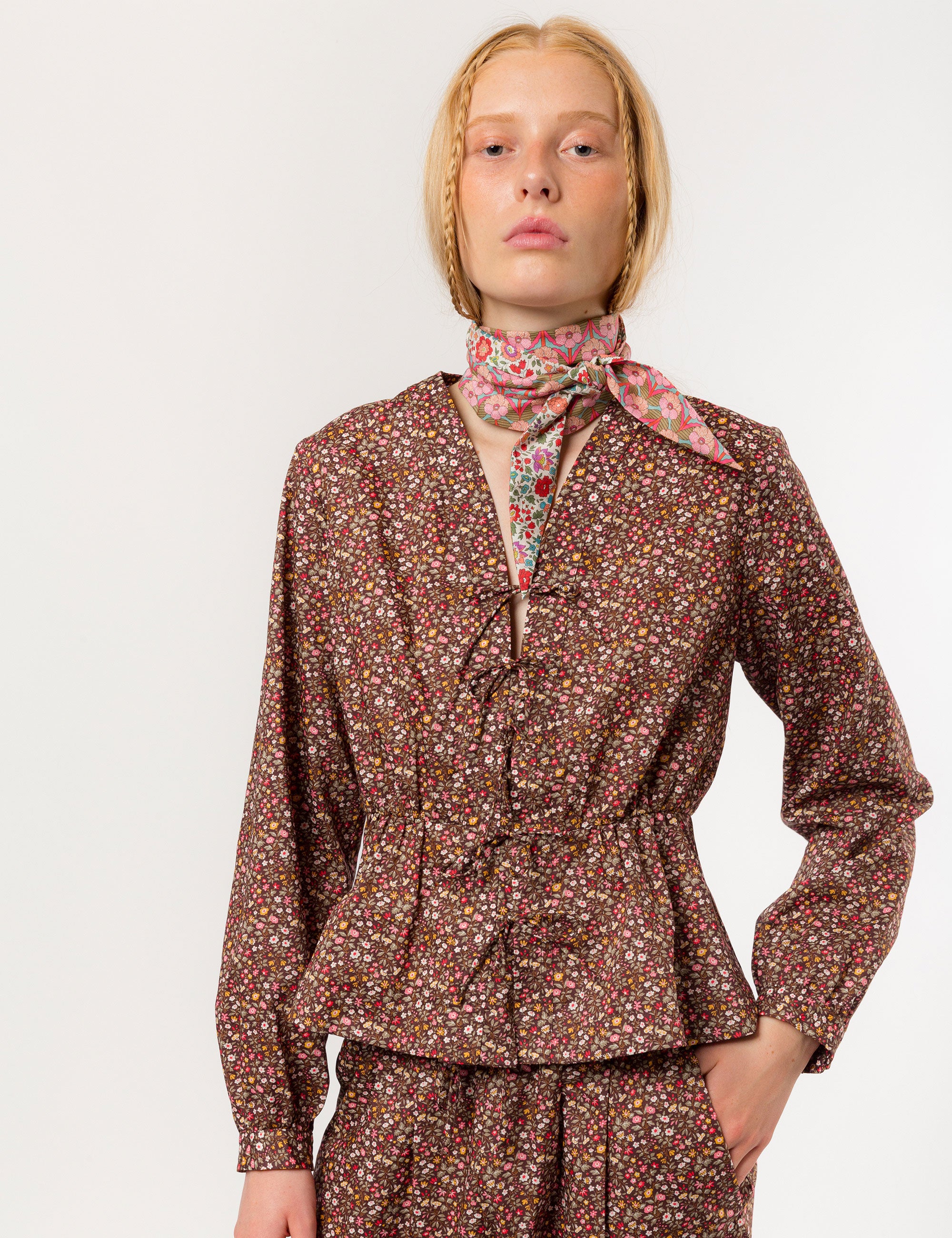 Woman in relaxed pants and matching long-sleeved v-neck shirt in liberty cotton brown and red small floral print