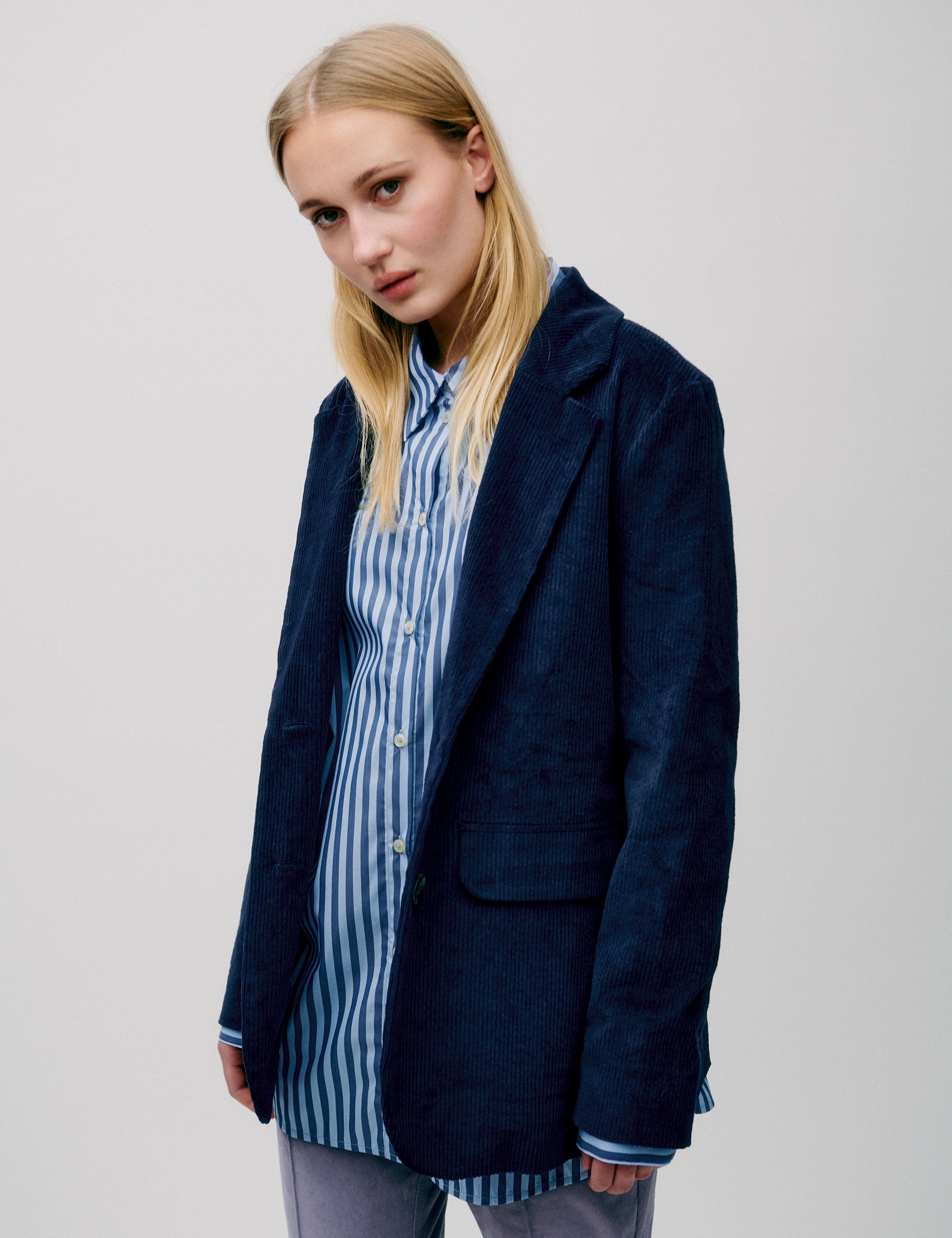 Women in straight blue striped cotton shirt and dark blue corduroy jacket