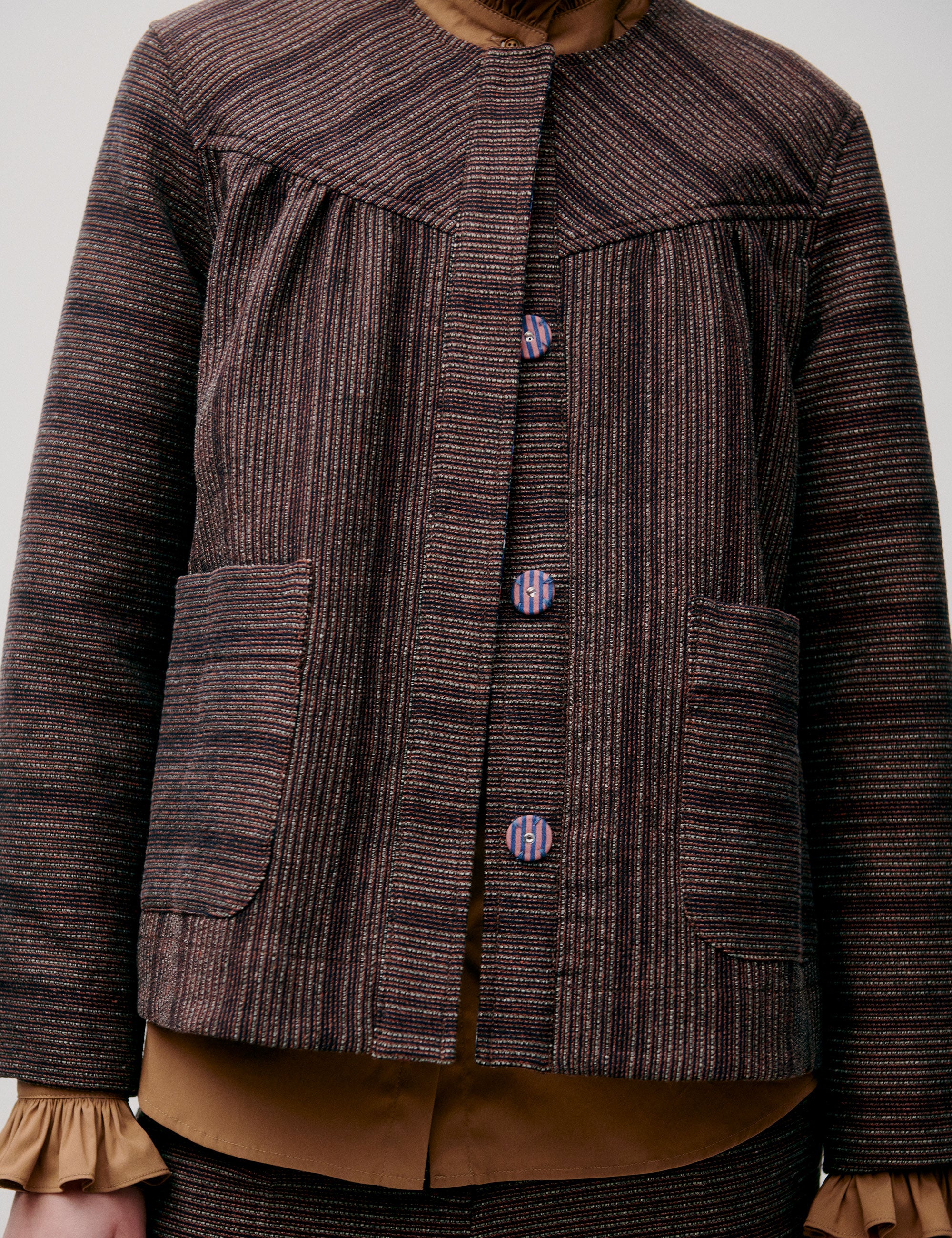 Woman in brown striped jacket with pockets and large buttons