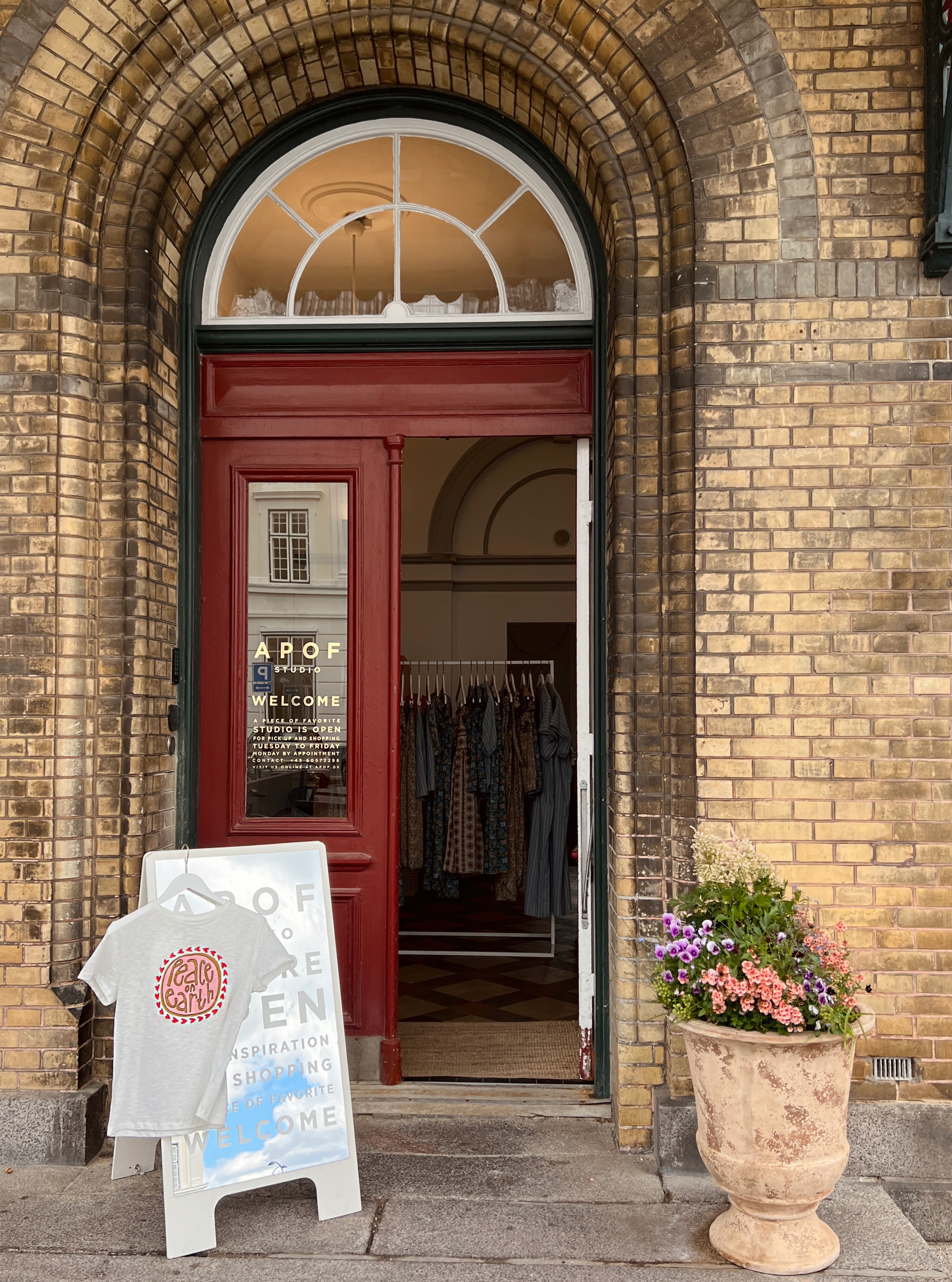 Entrance to APOF shop with sign t-shirt and flower pot