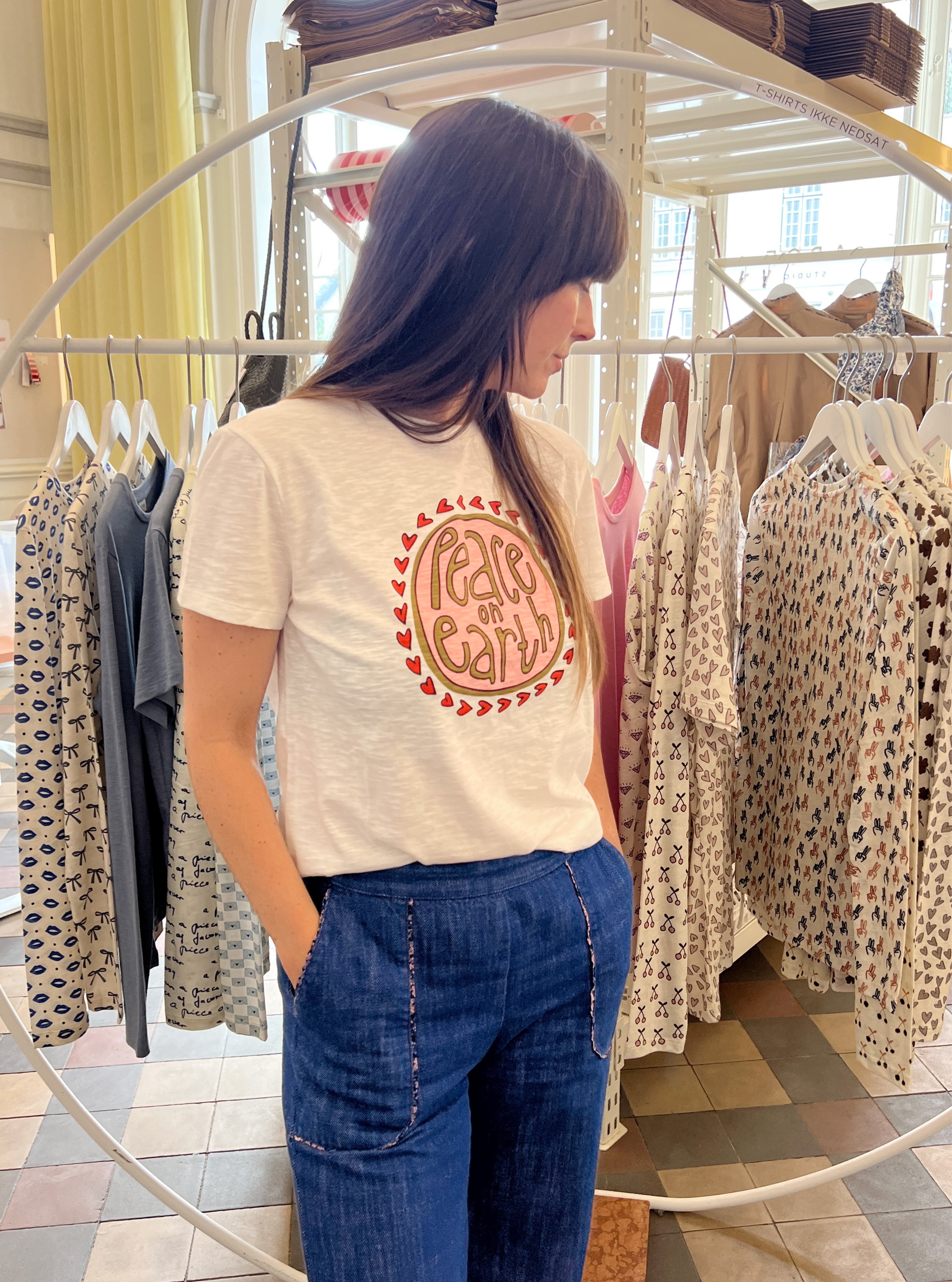 Woman with jeans and t-shirt with text peace on earth