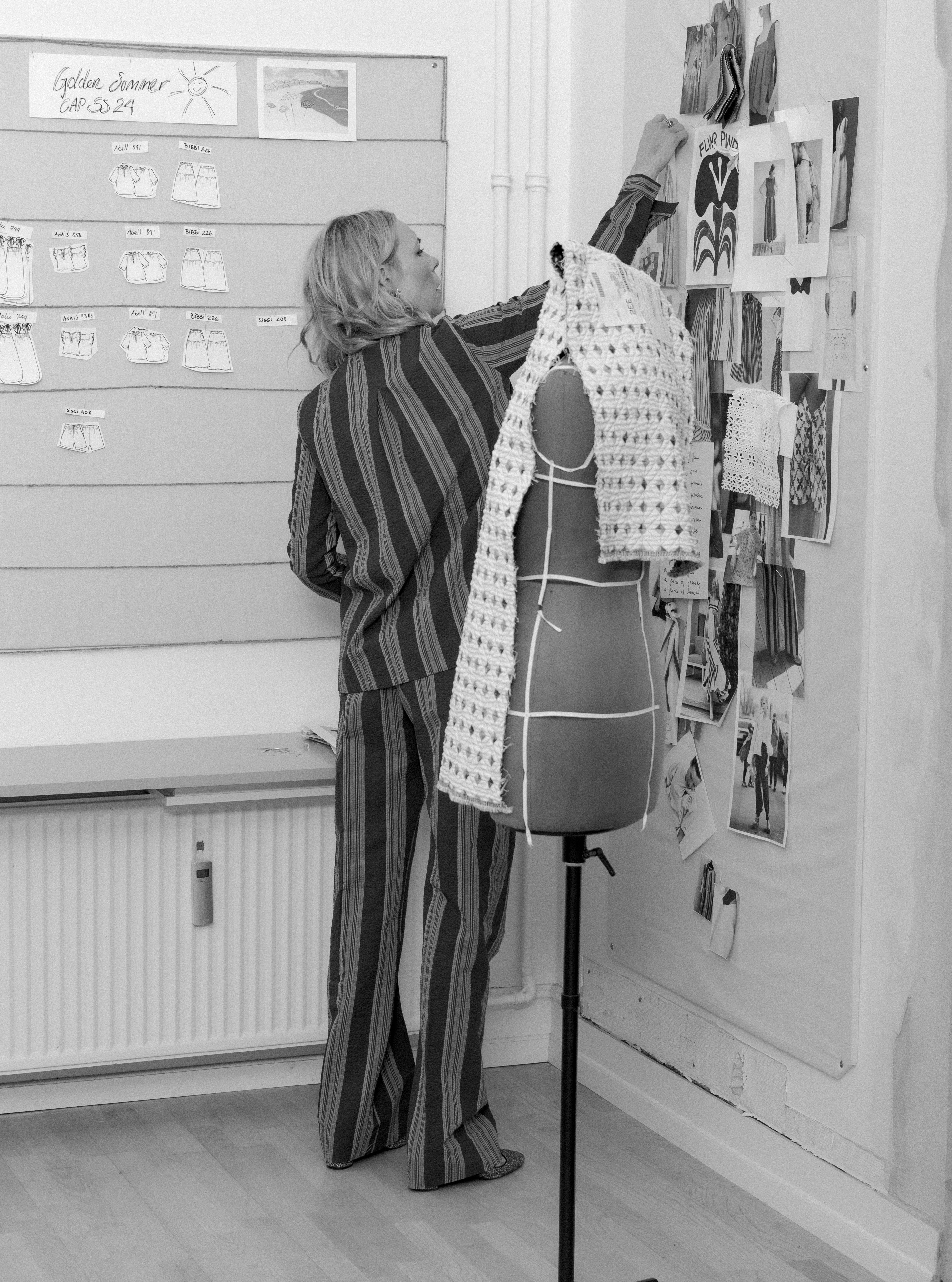 Woman in striped costume putting note on wall