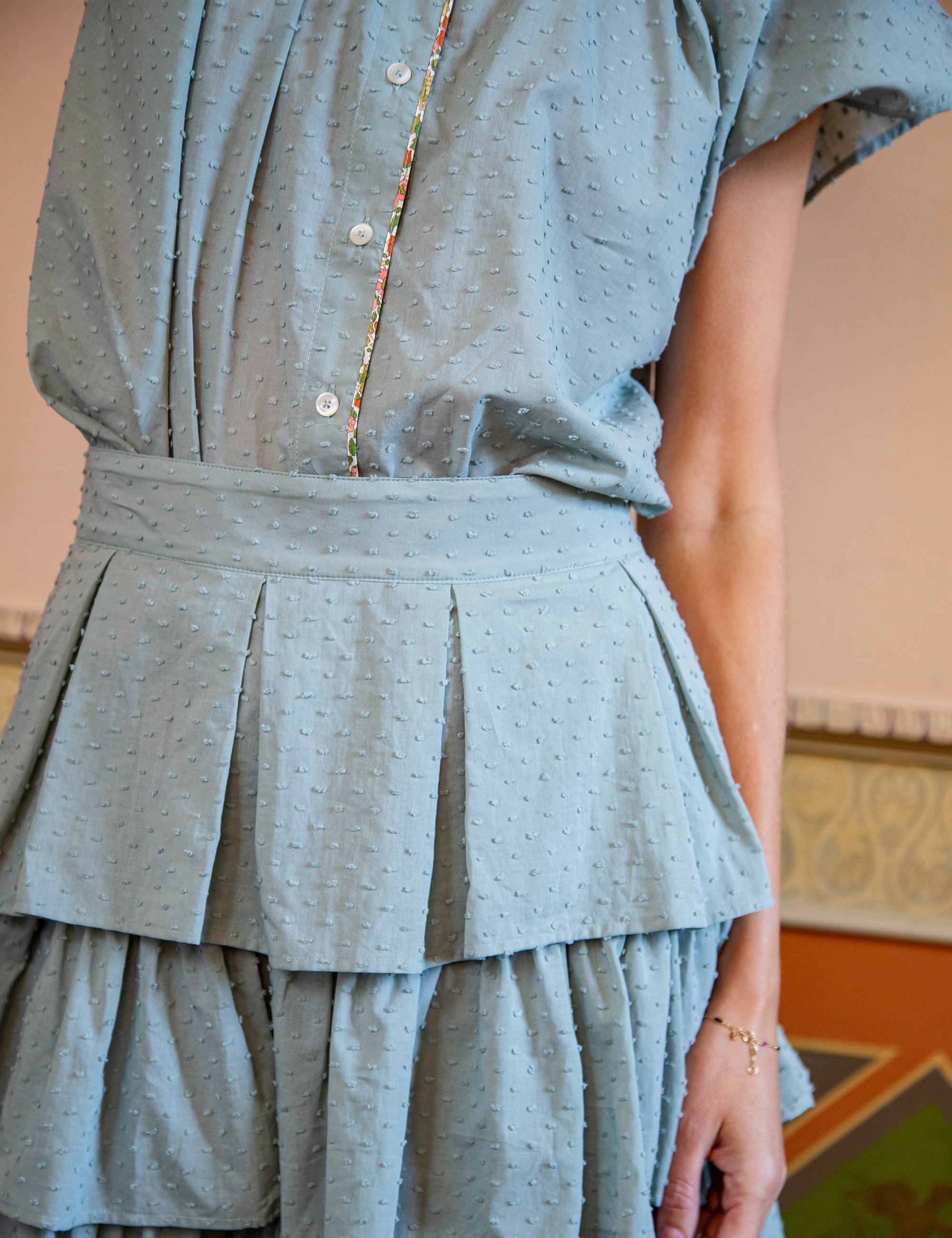 Woman wearing a light green top and layered skirt