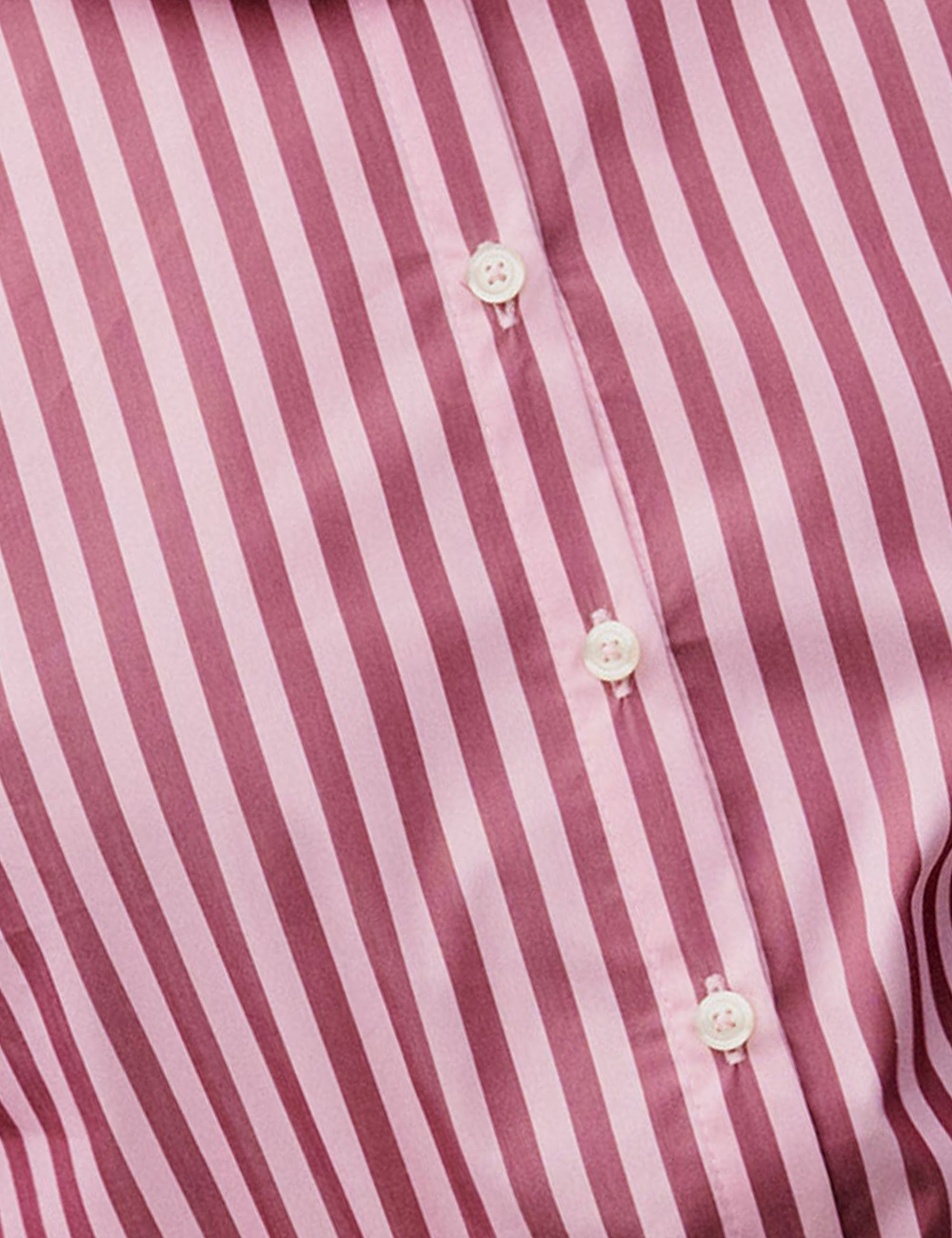 Close-up of a women's shirt with pink and white vertical stripes and buttons.