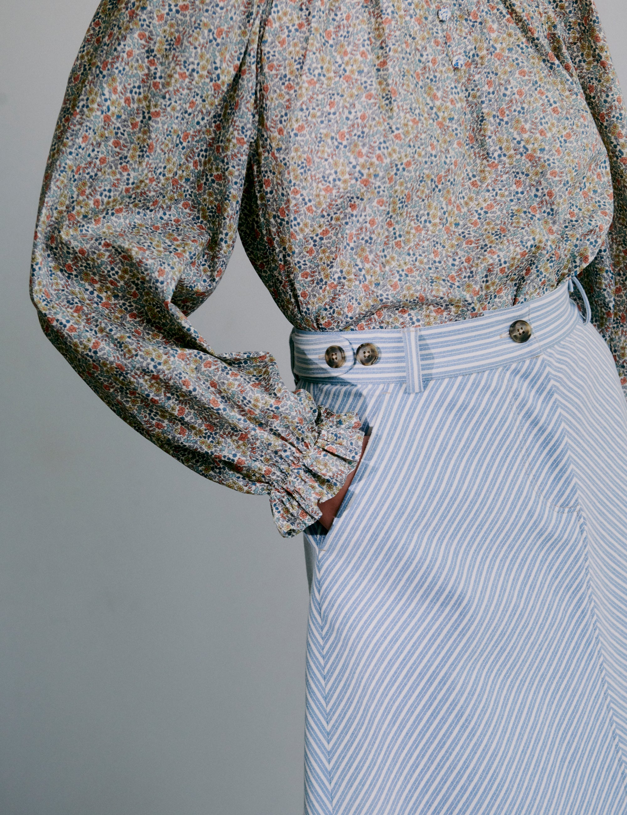 Floral blouse with long sleeves and blue and white striped skirt
