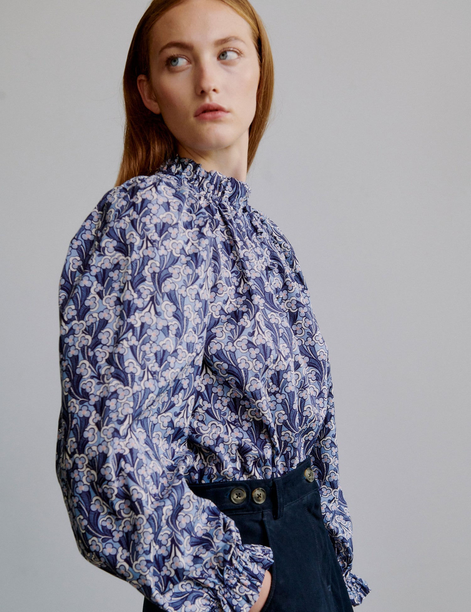 Woman wearing a blue floral blouse and blue a-line skirt