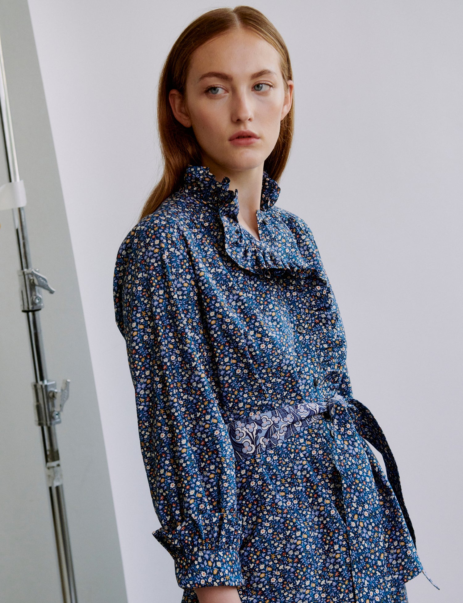 Woman wearing a blue floral shirt against a plain background