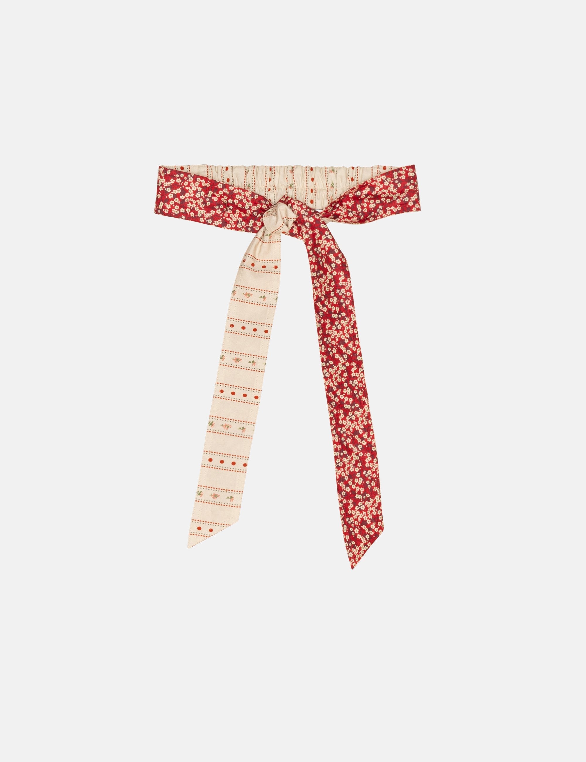Decorative fabric belt with red and white pattern on a white background