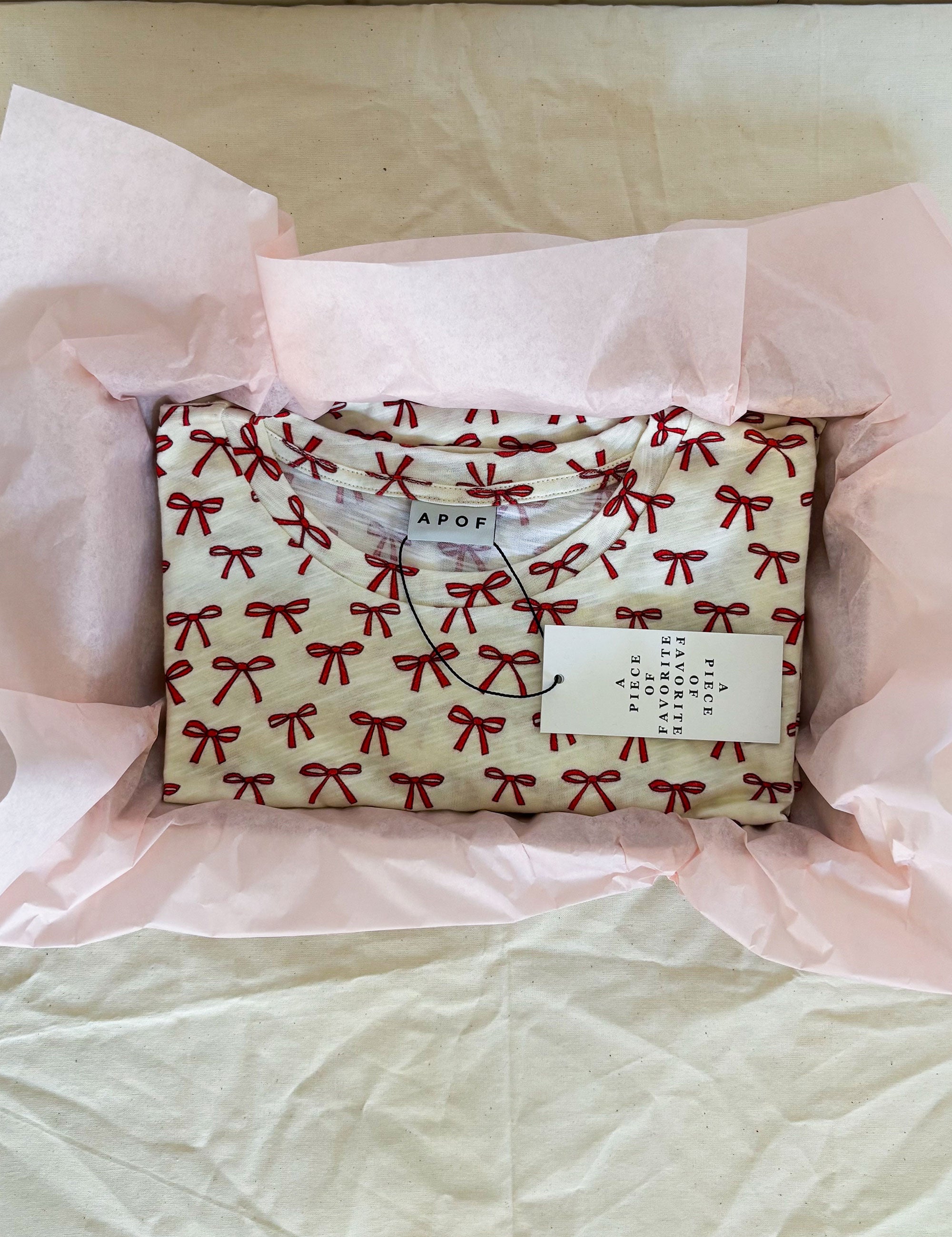 Folded t-shirt with red bow pattern on wrapping paper