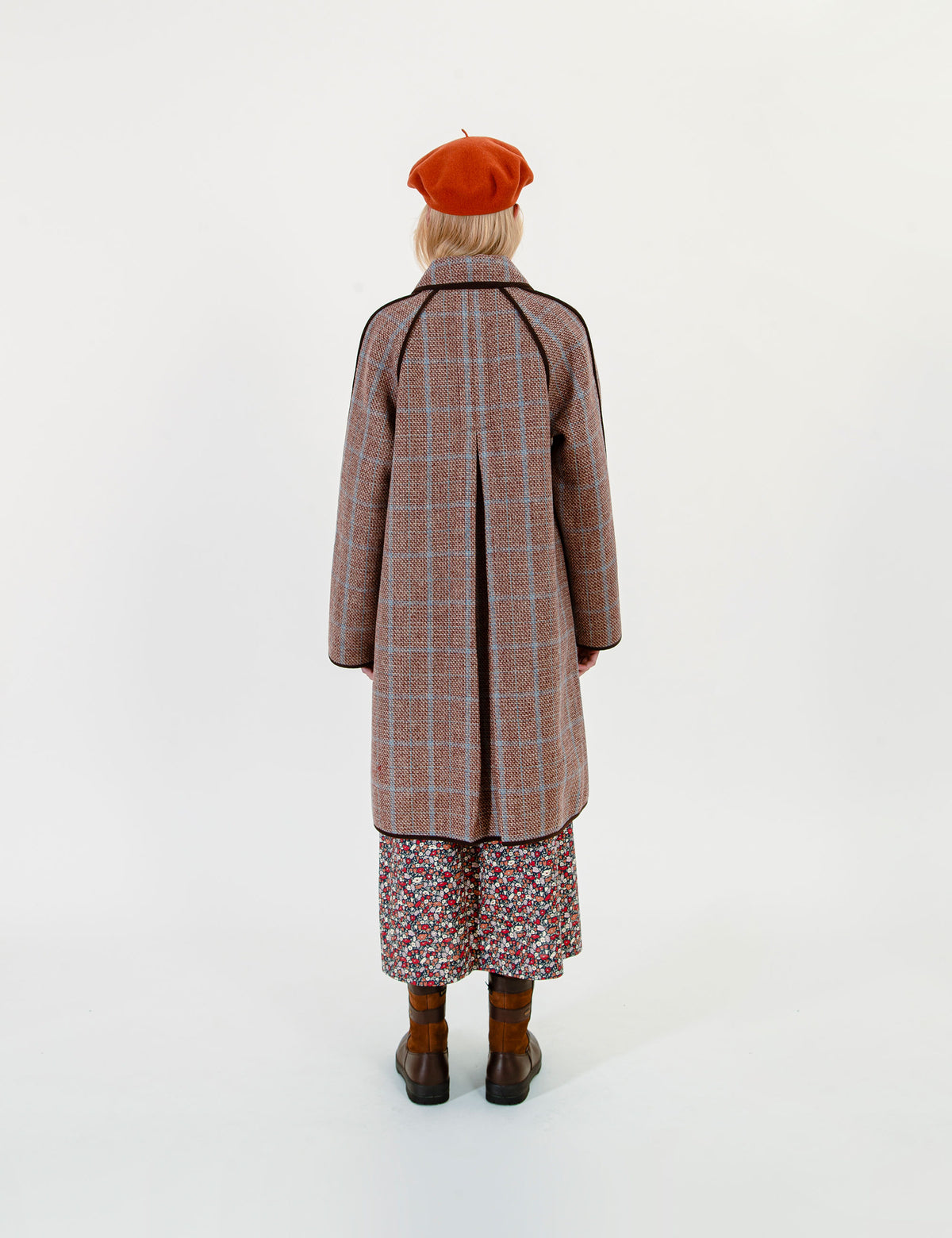 Woman wearing a plaid coat and red beret on a white background