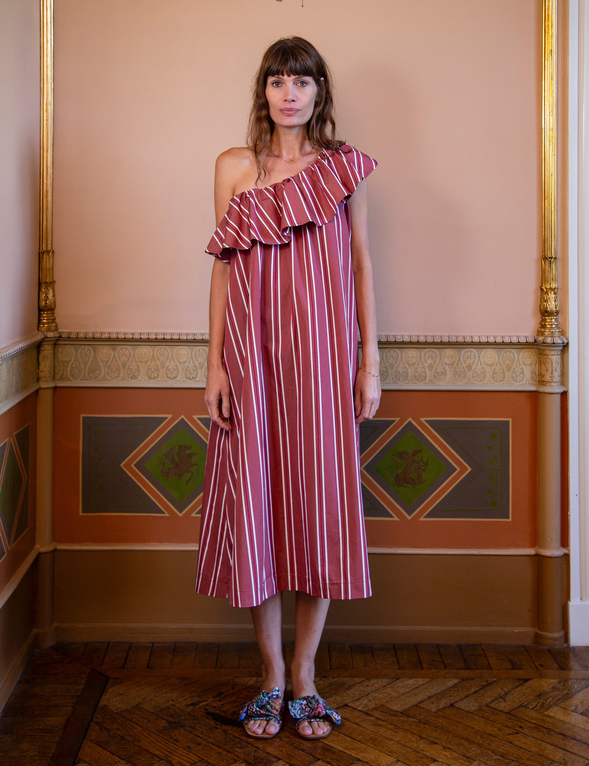 Woman wearing a red and white striped one shoulder dress