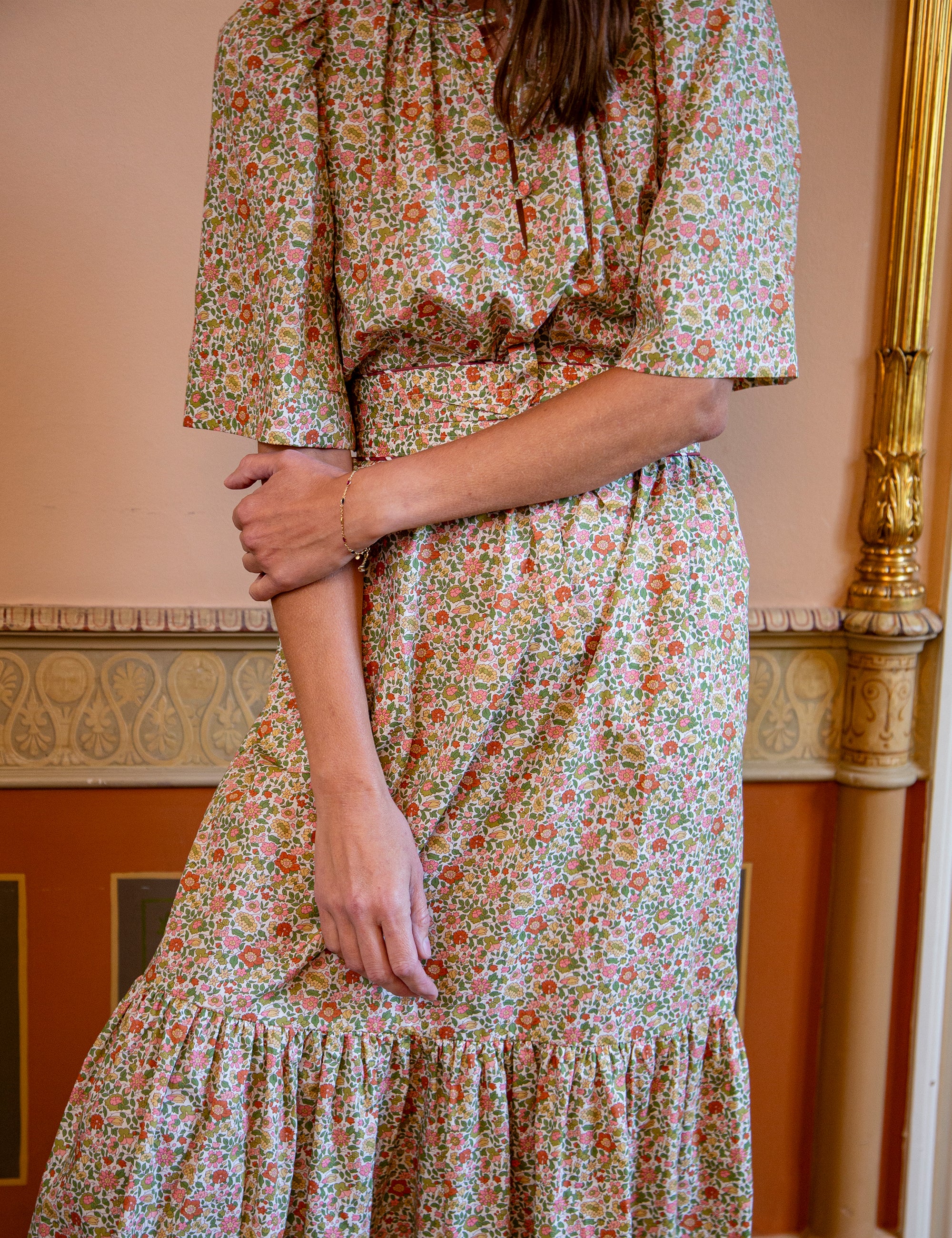 Person wearing a floral dress with a matching fabric belt