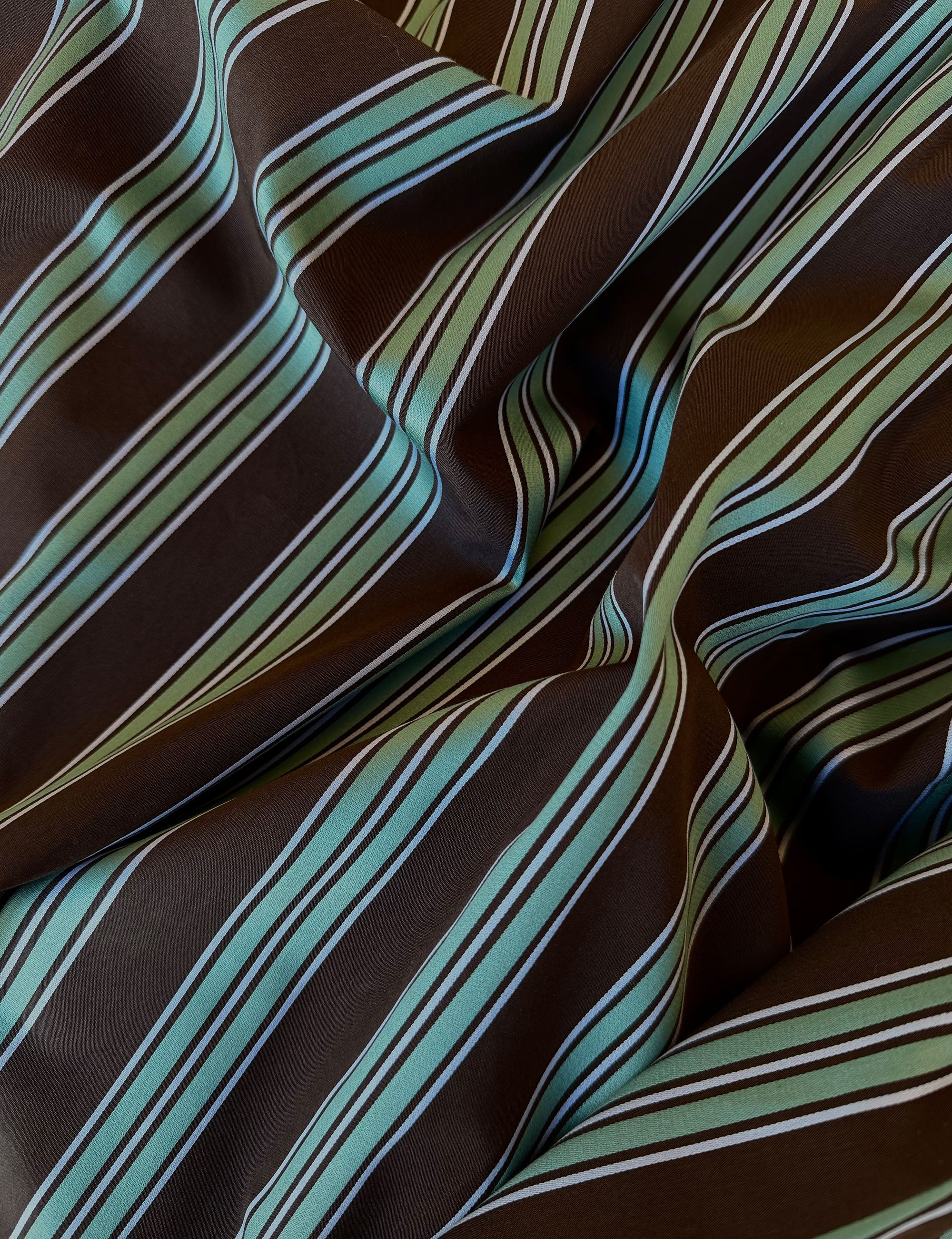 Close-up of brown fabric with green and white striped pattern