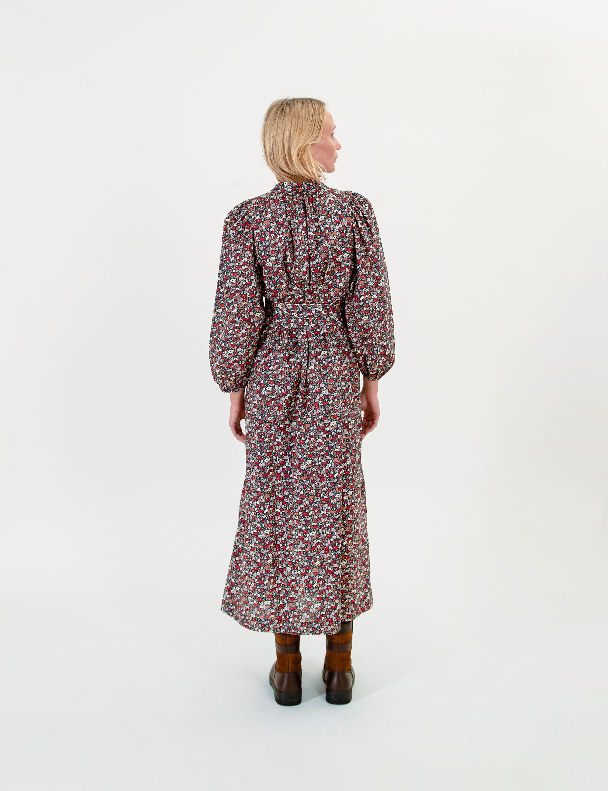 Woman wearing a floral maxi dress on a white background