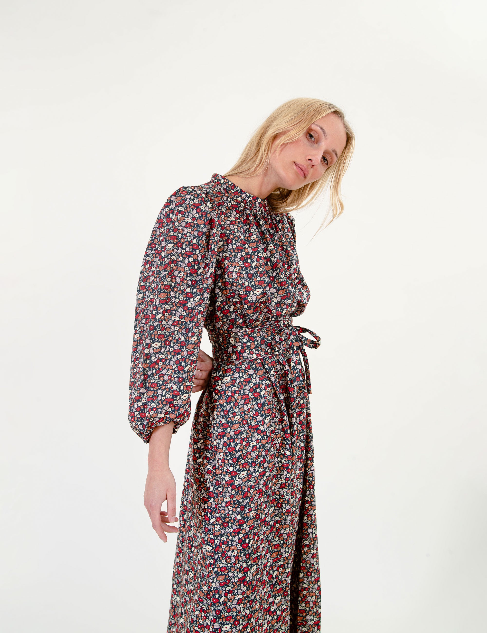 Woman wearing a floral maxi dress on a white background
