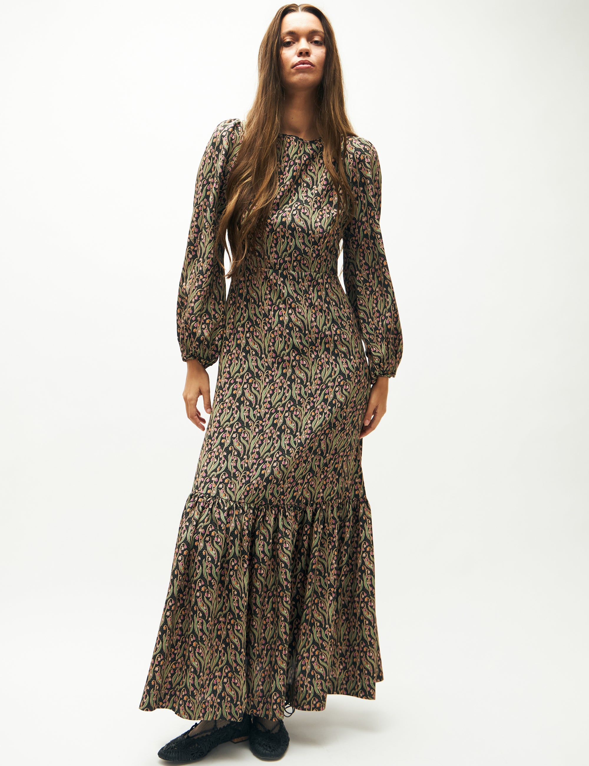 Woman in green and pink flower patterned maxi dress with long puff sleeves
