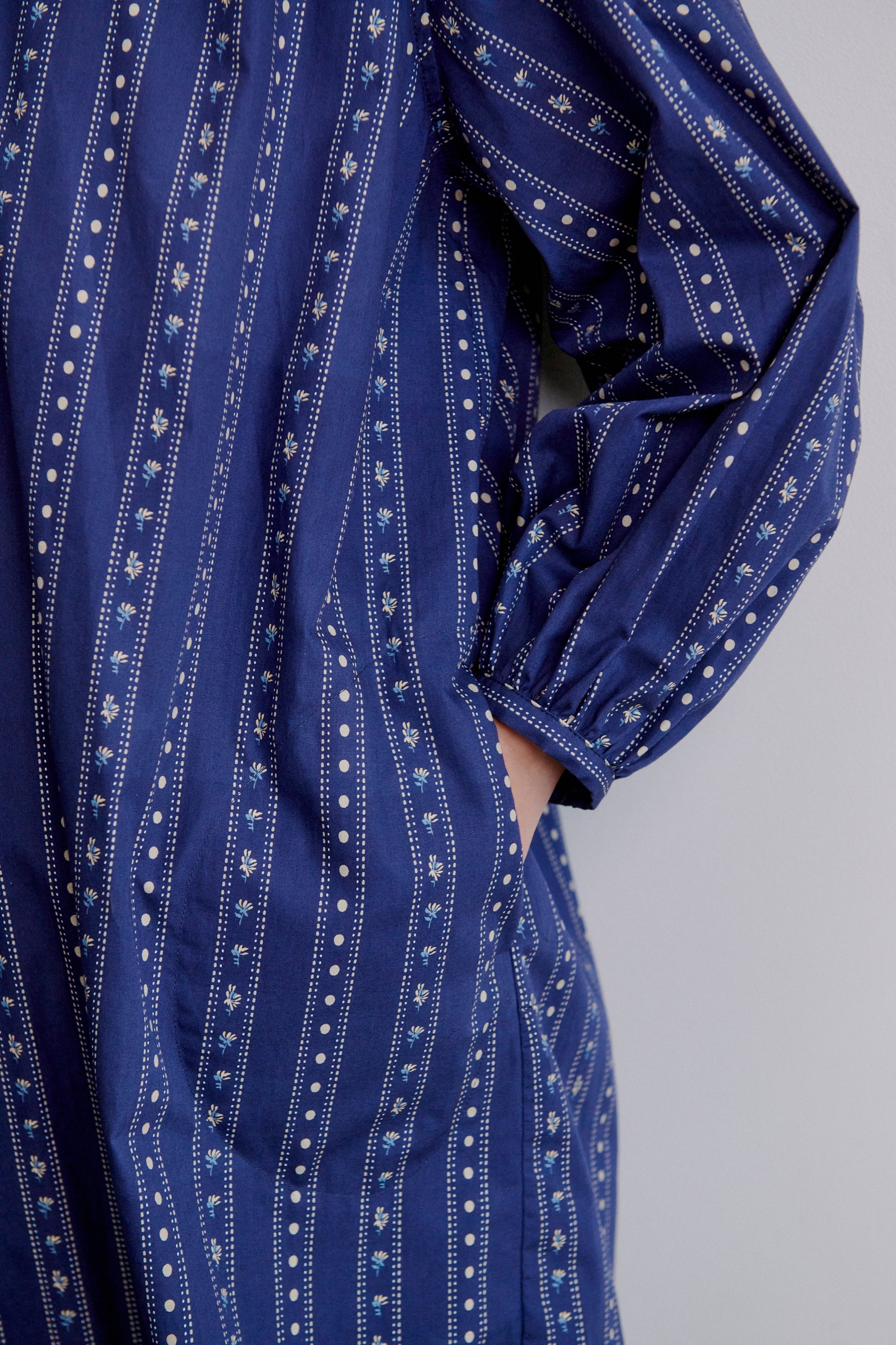 Blue stripe patterned women's shirt with long sleeves on a plain background