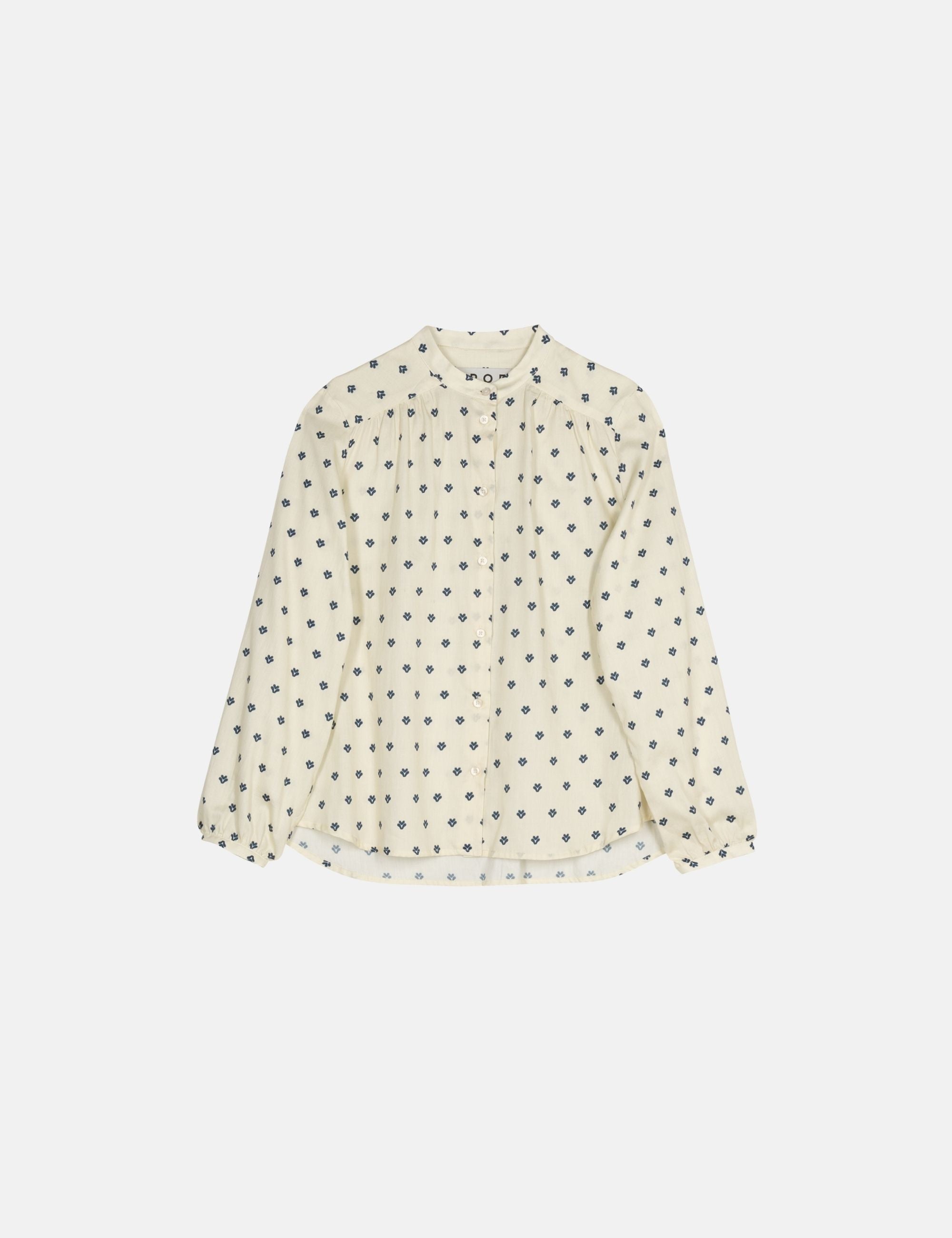 White blouse with black polka dot pattern on a white background