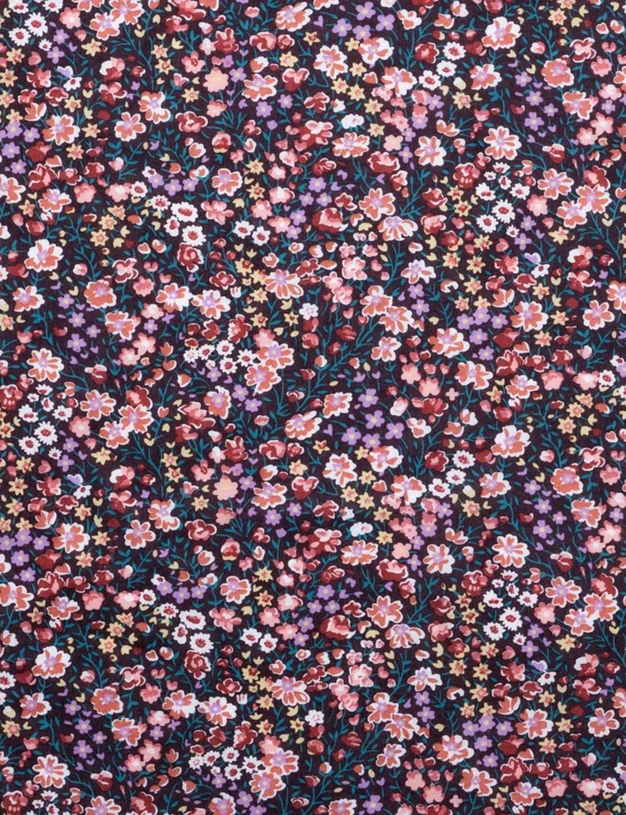 Close-up of small floral print fabric in pink, red, and white on dark background