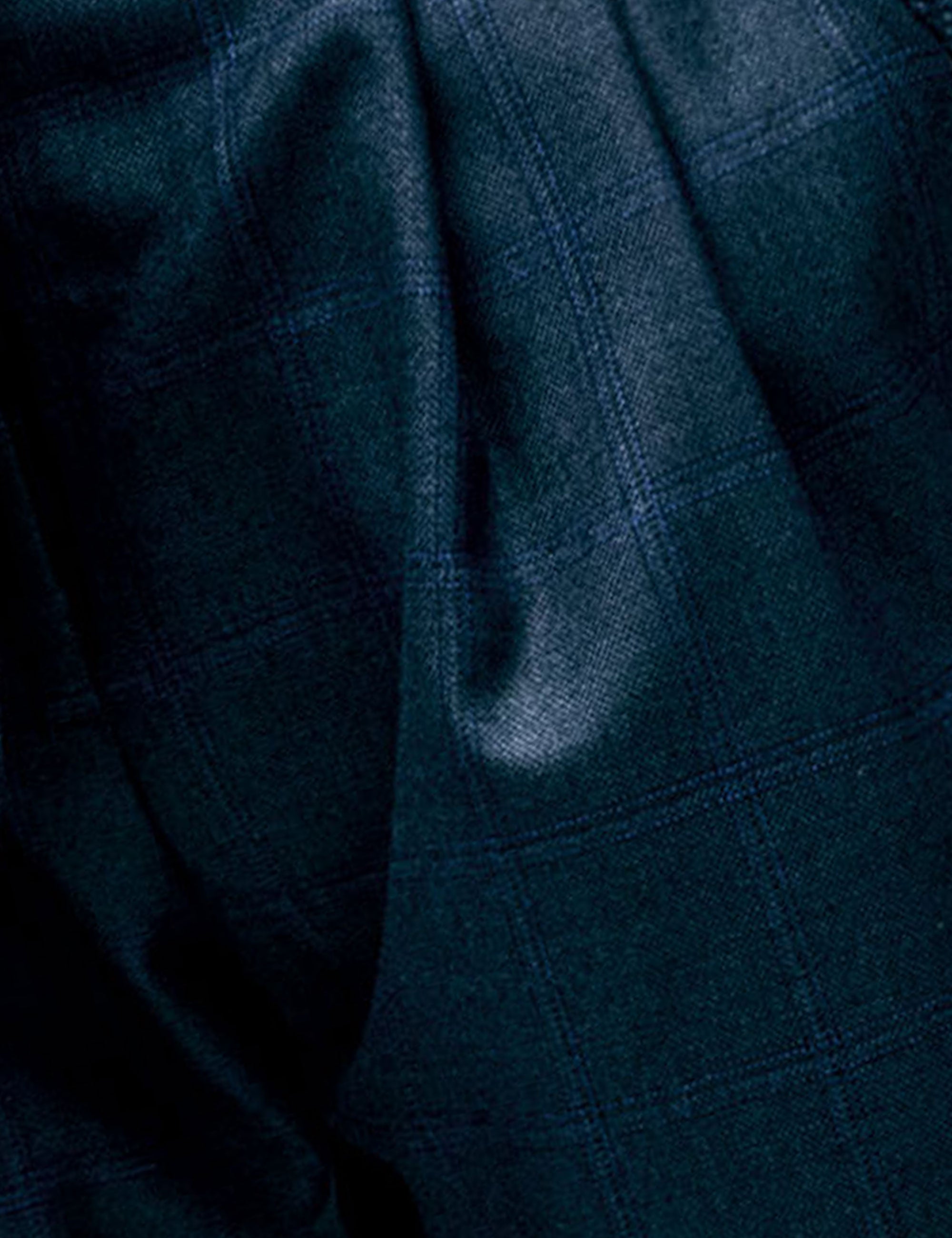 Close-up of dark suiting fabric with soft sheen and subtle texture