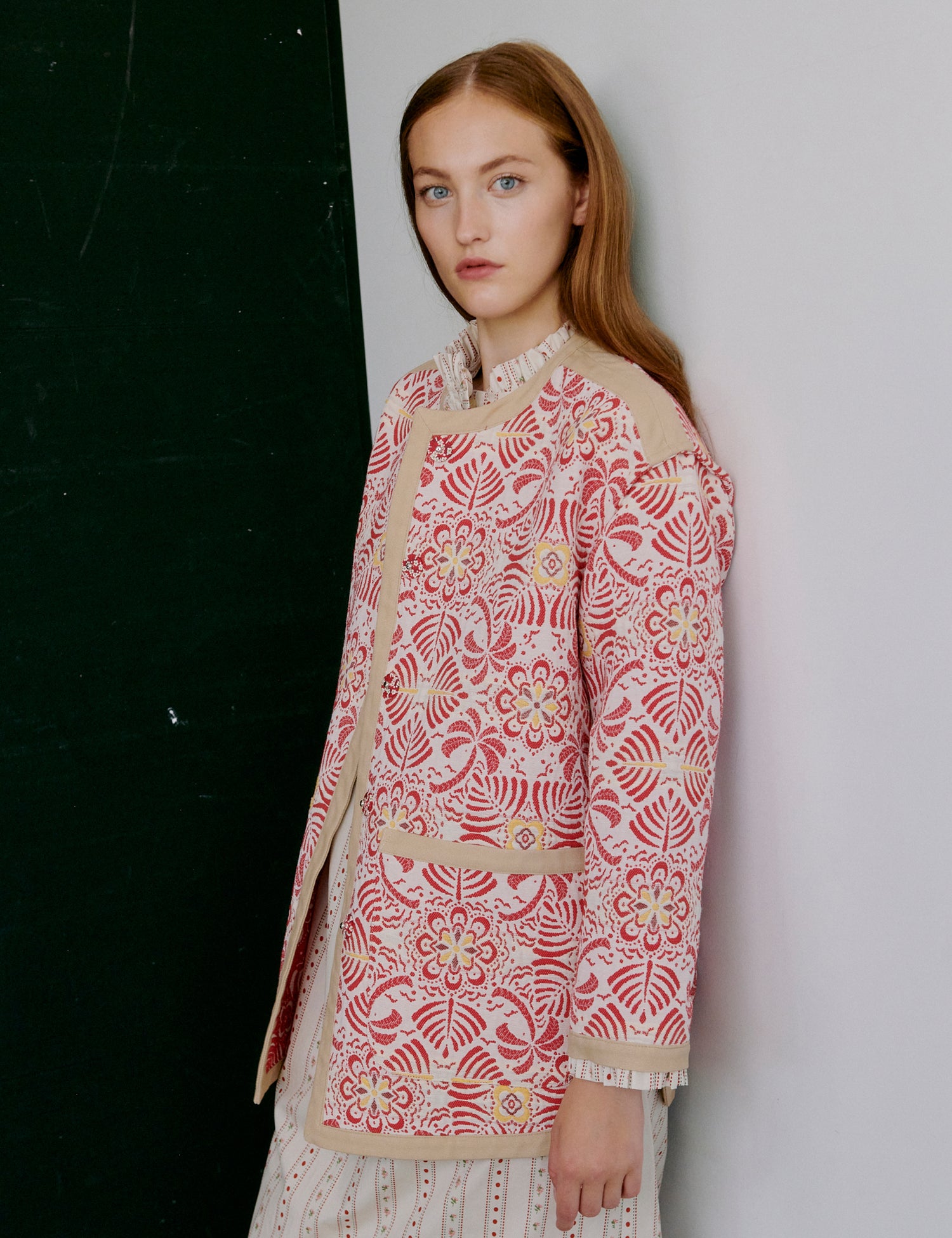 Woman wearing a patterned pink and beige sweater against a plain background