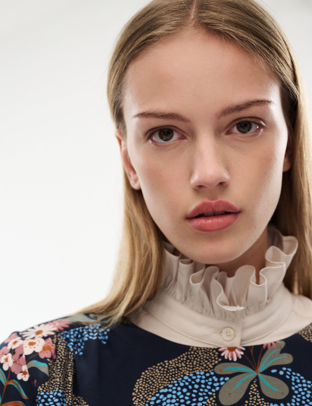 Printed blouse neckline with ruffled beige stand collar and dark navy floral butterfly pattern