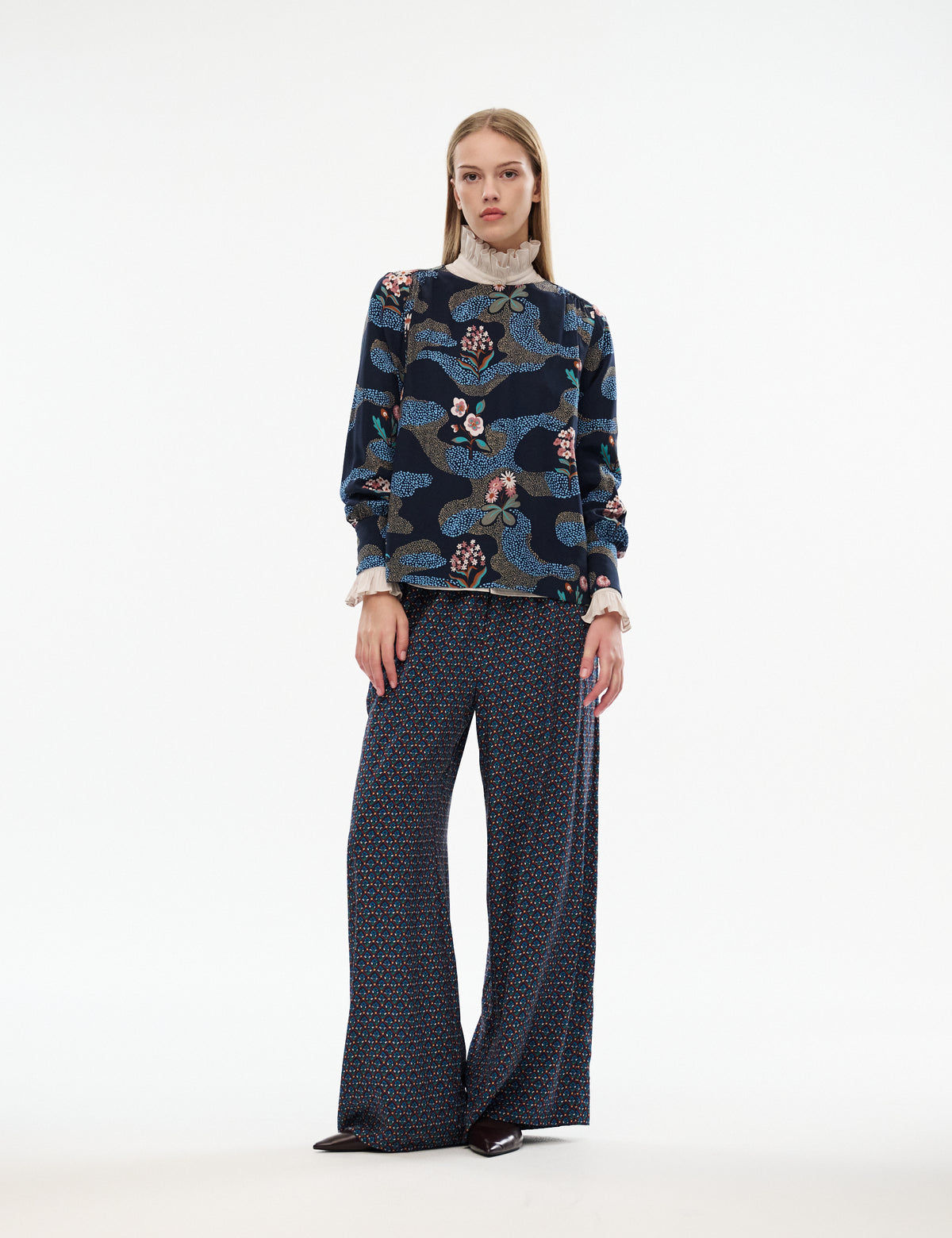 Printed long-sleeve blouse with dark navy floral butterfly print and ruffled beige stand collar