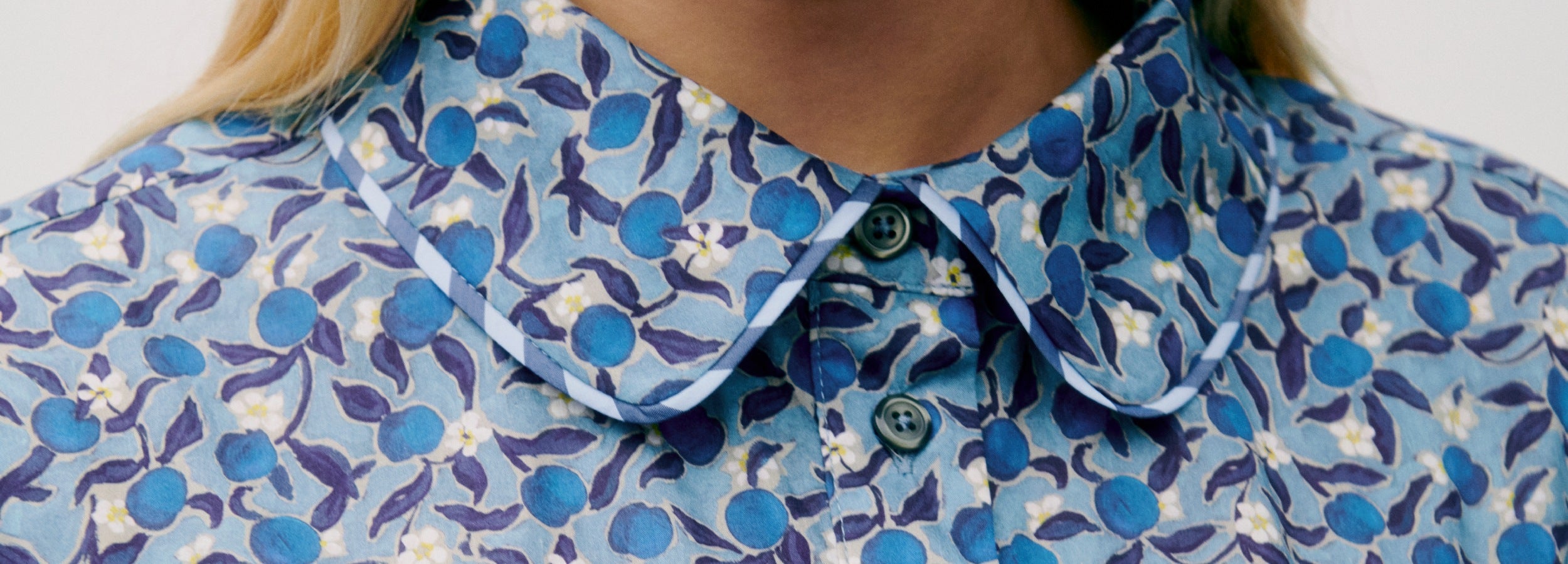 Woman in blue floral print dress with classic collar