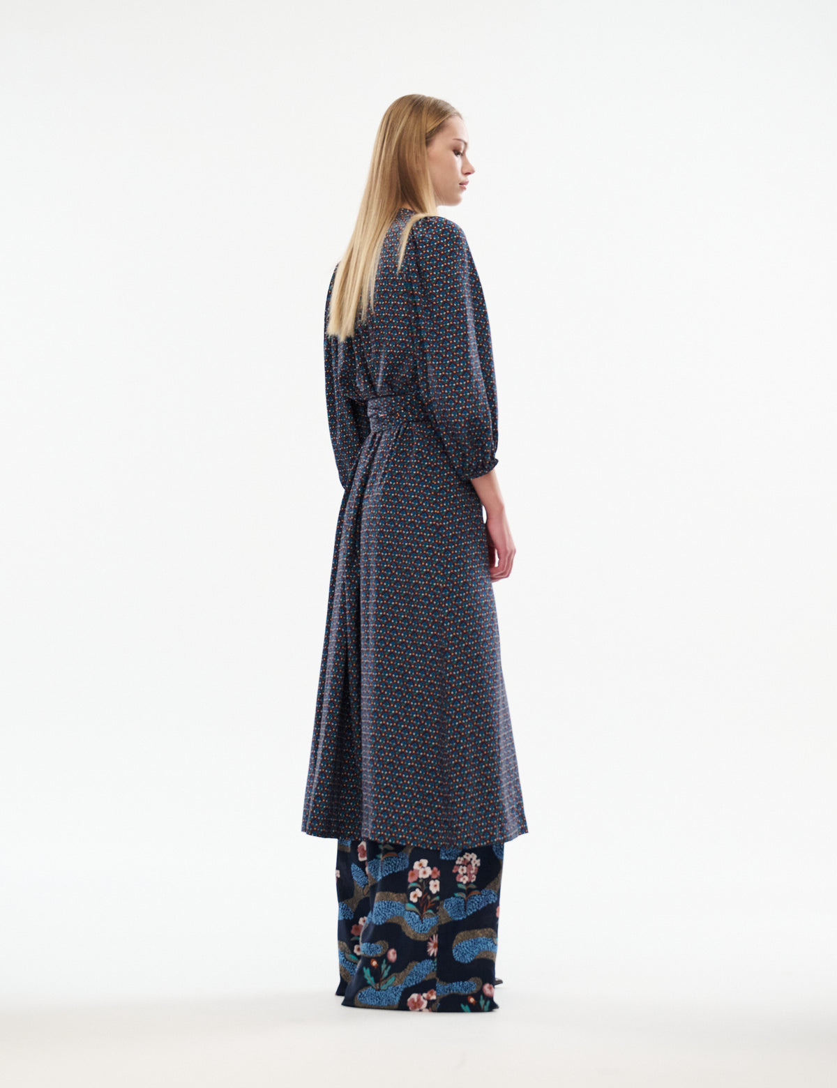 Women’s navy patterned midi dress, side view, tied waist belt and long sleeves