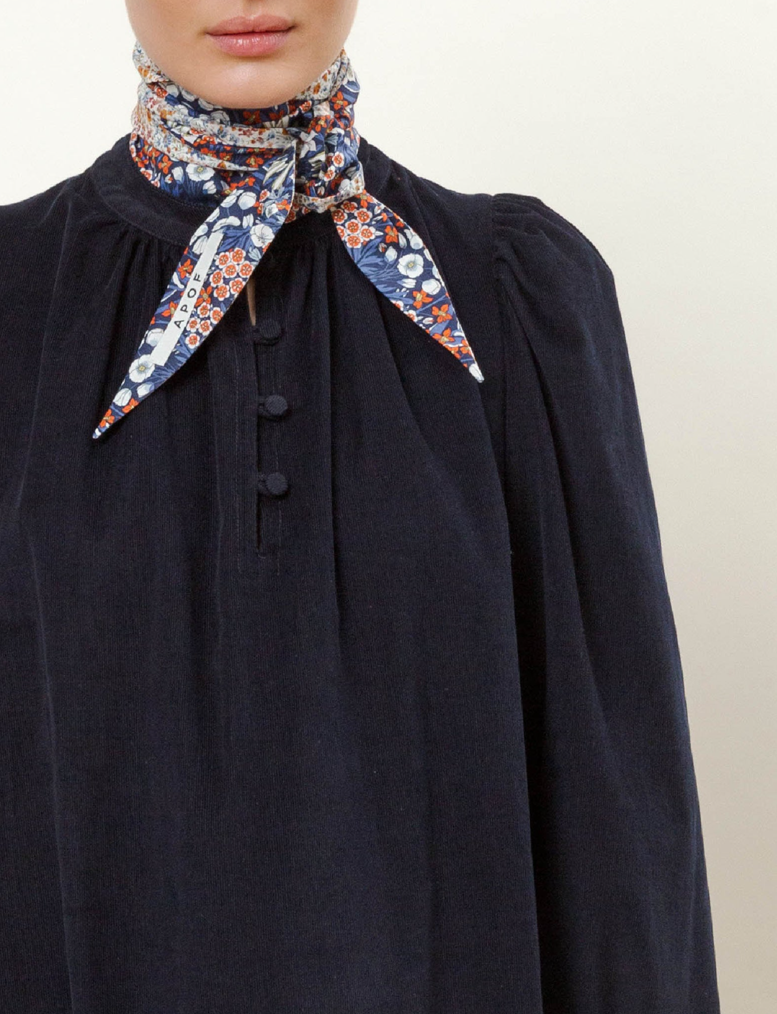 Woman in long navy blue corduroy dress with flower patterned scarf