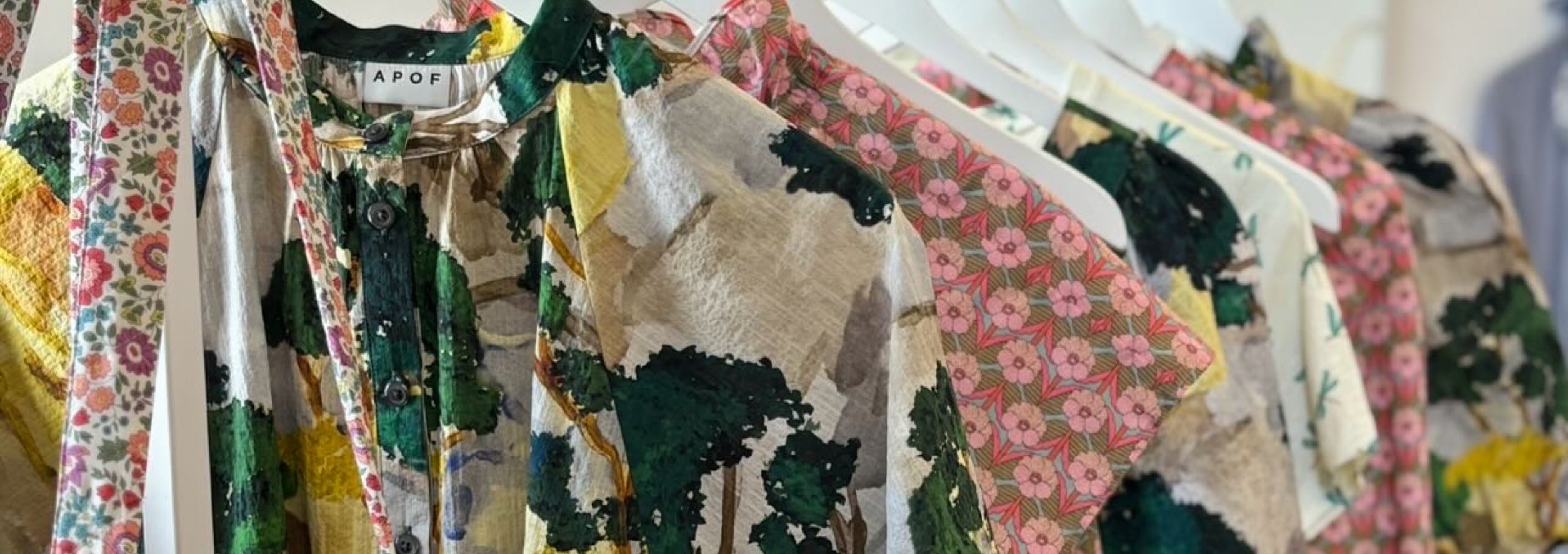 Rack with flower patterned women's summer clothes and a bag from APOF 