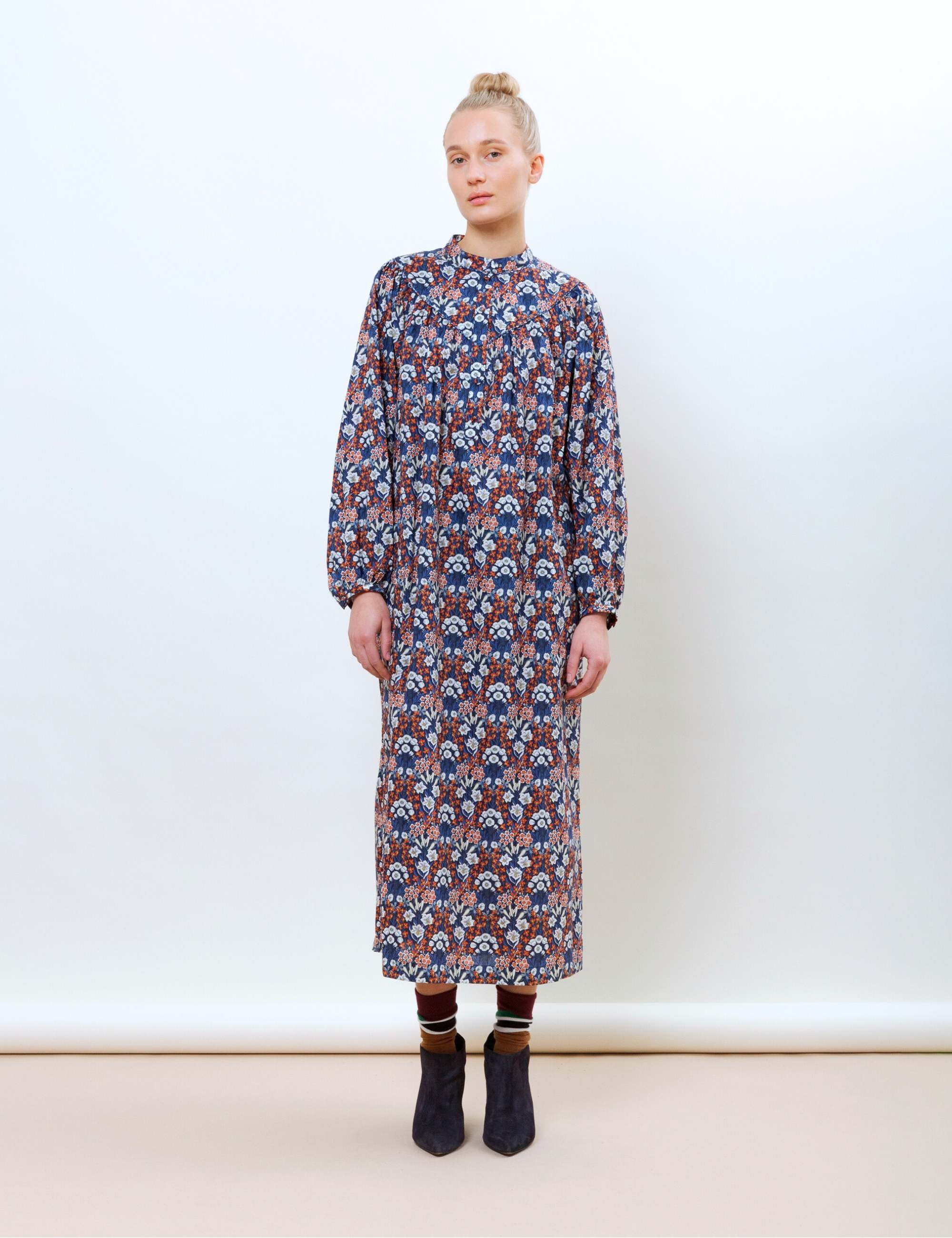 Woman in long sleeved long dress with Liberty primrose print in red blue and white