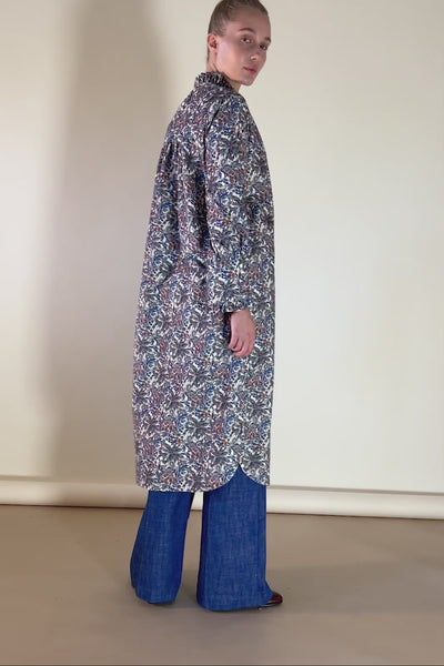 Woman in blue wide pants and kaftan dress in baby corduroy with farraway paisley print in blue brown and orange