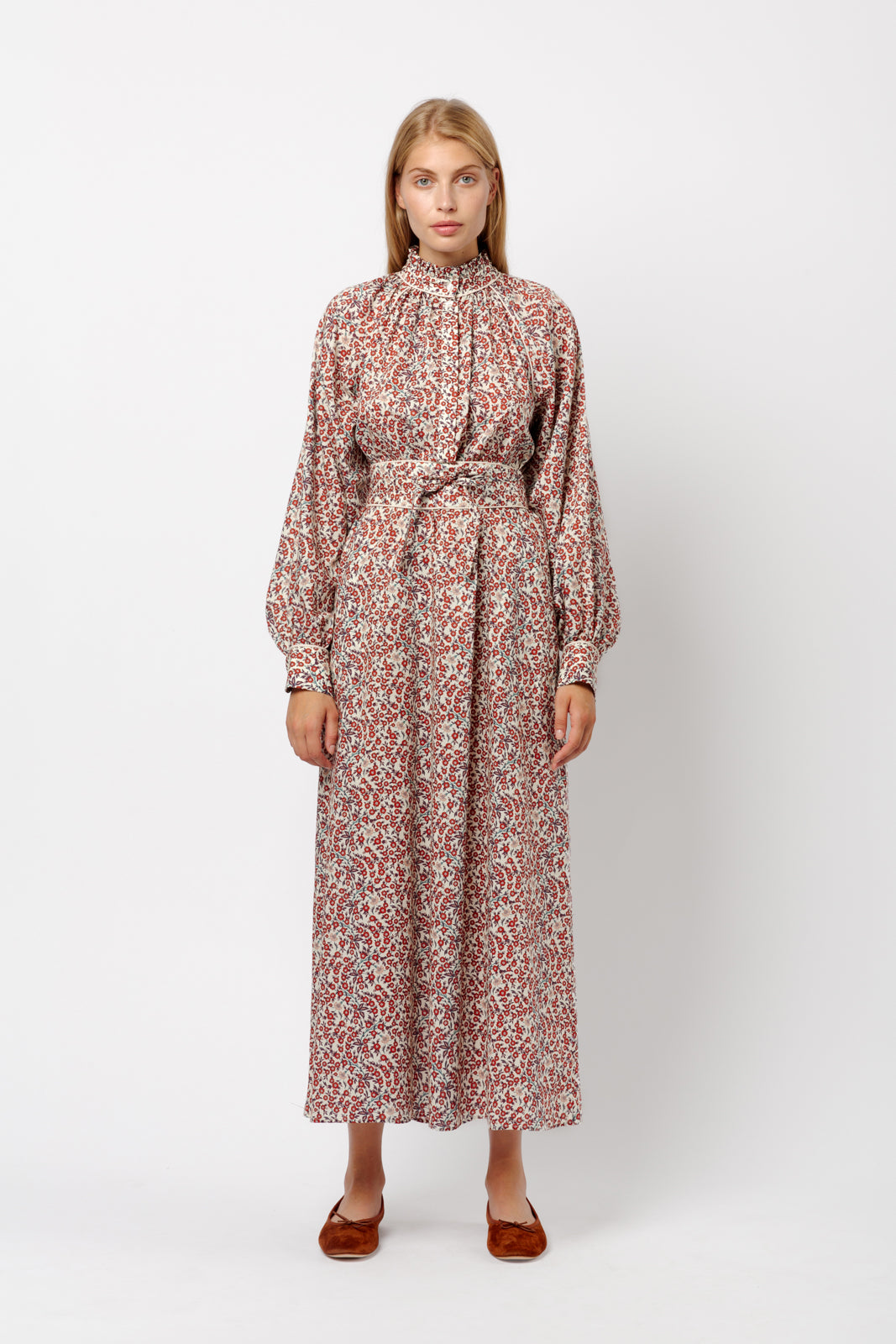 Woman in long dress with red flower pattern, puffed long sleeves and red shoes 